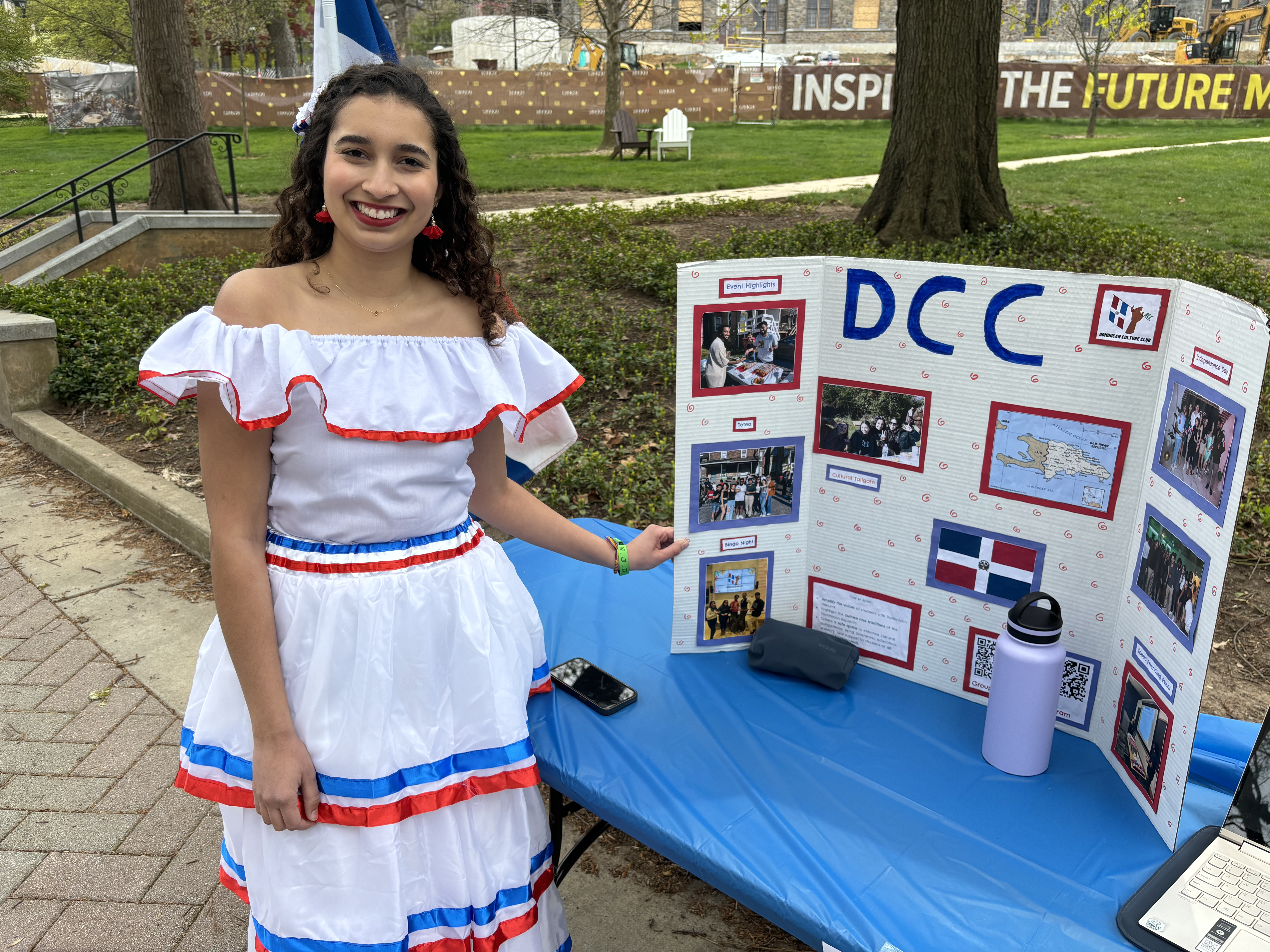 A woman wearing a traditional Dominican dress at an information table at Lehigh University