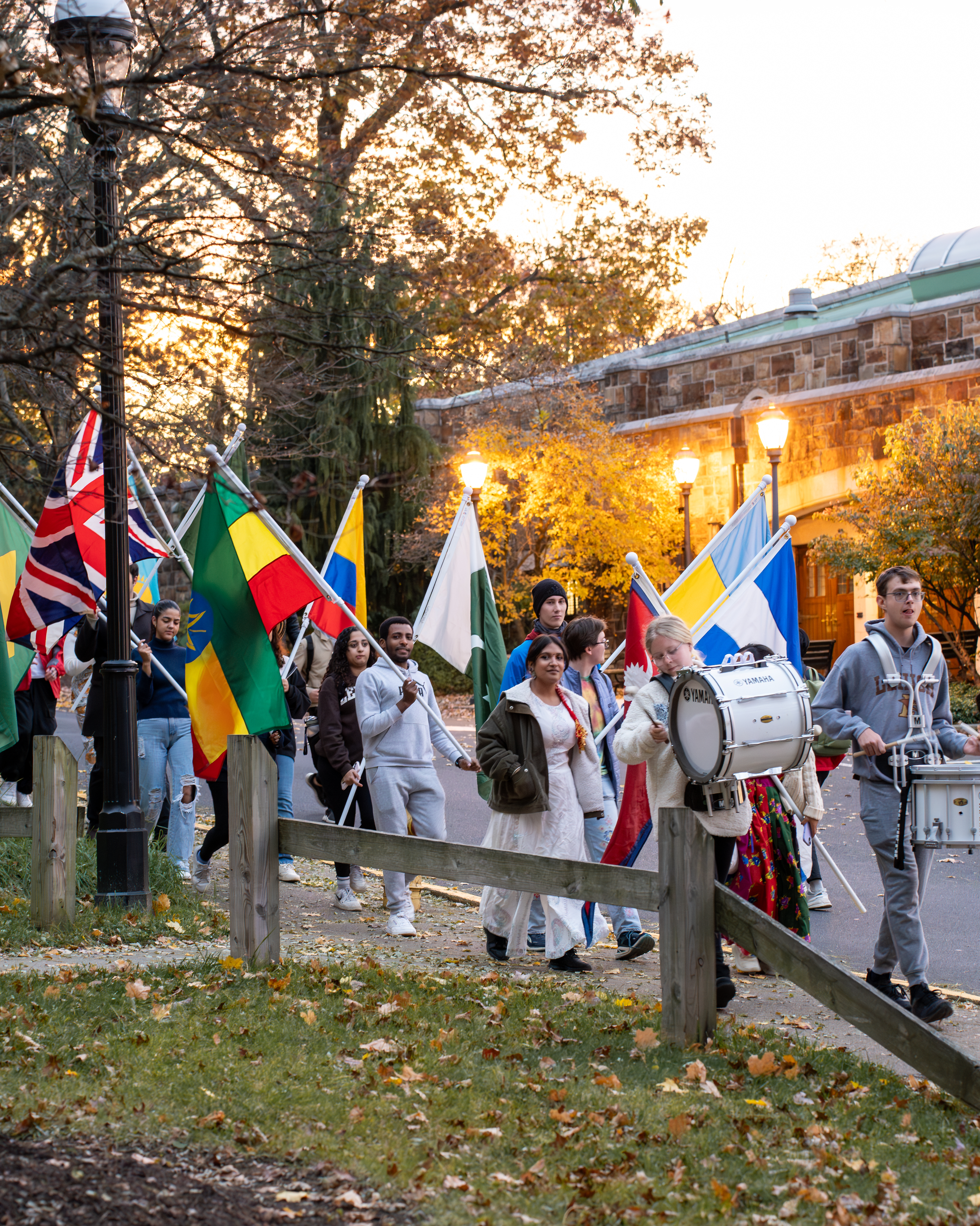 Students carrying various flags while walking in a parade on the campus of Lehigh University