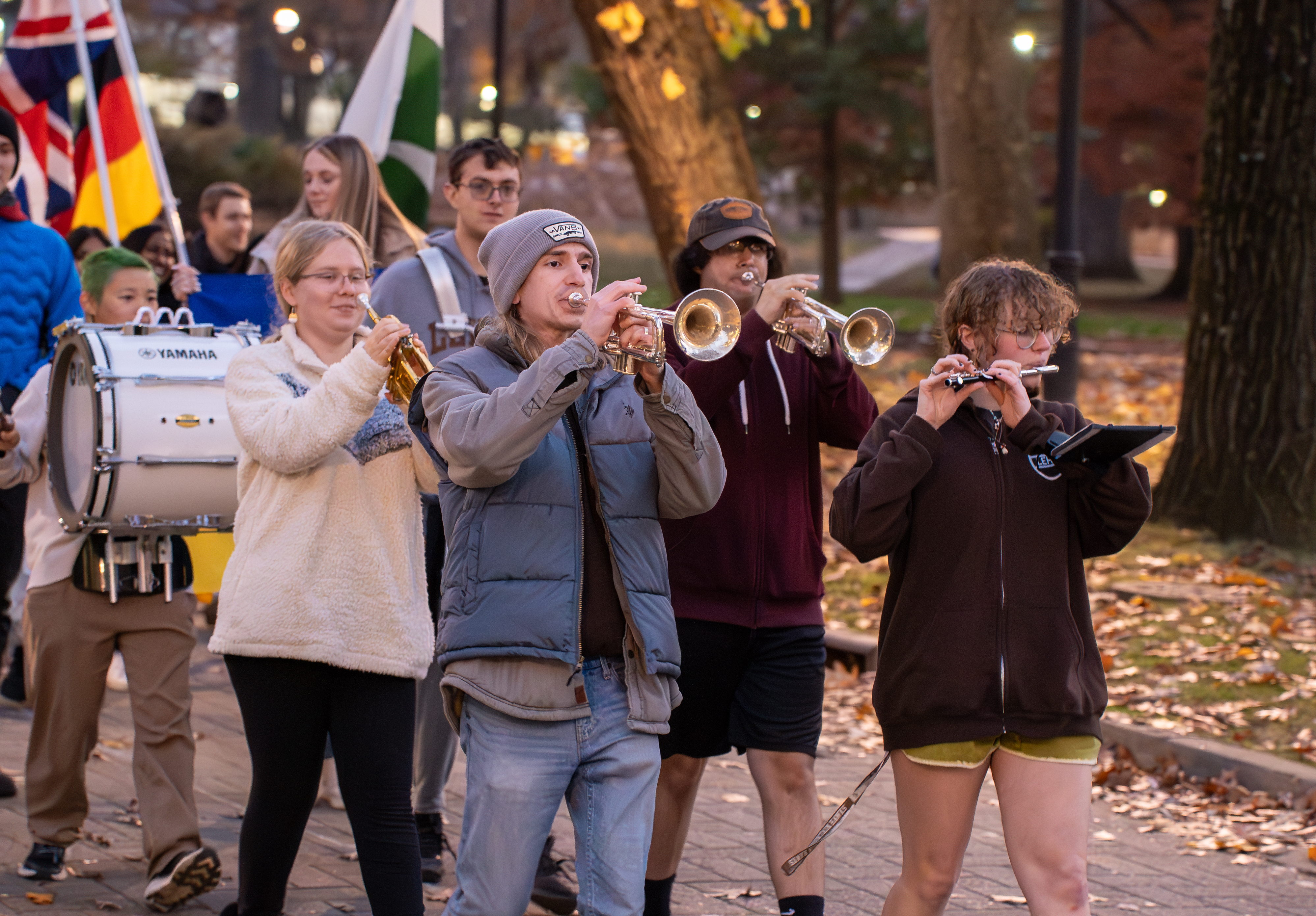 Students marching in a parade at Lehigh University, with some playing instruments and others carrying flags