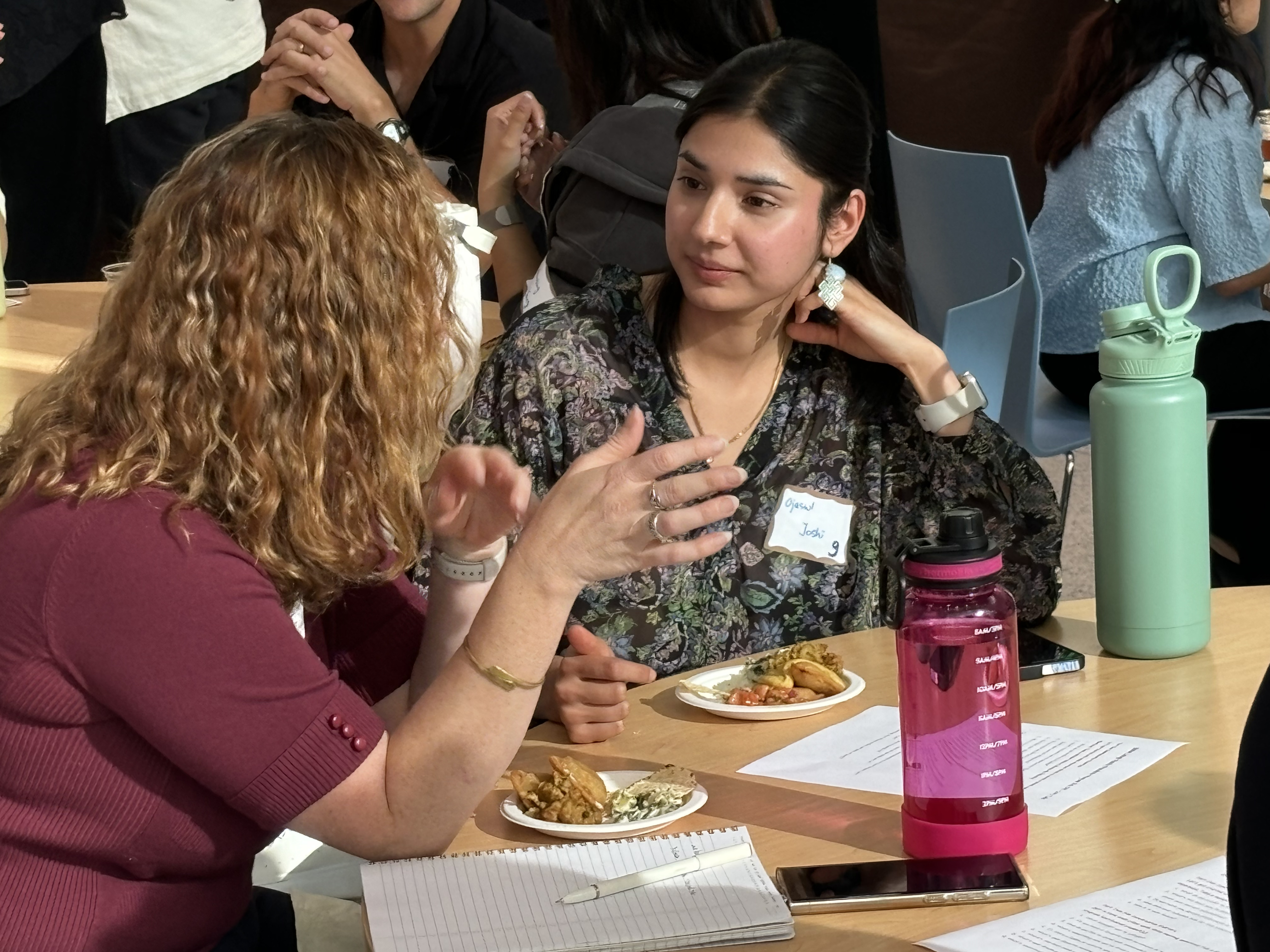 A woman listening to another woman speak at a table