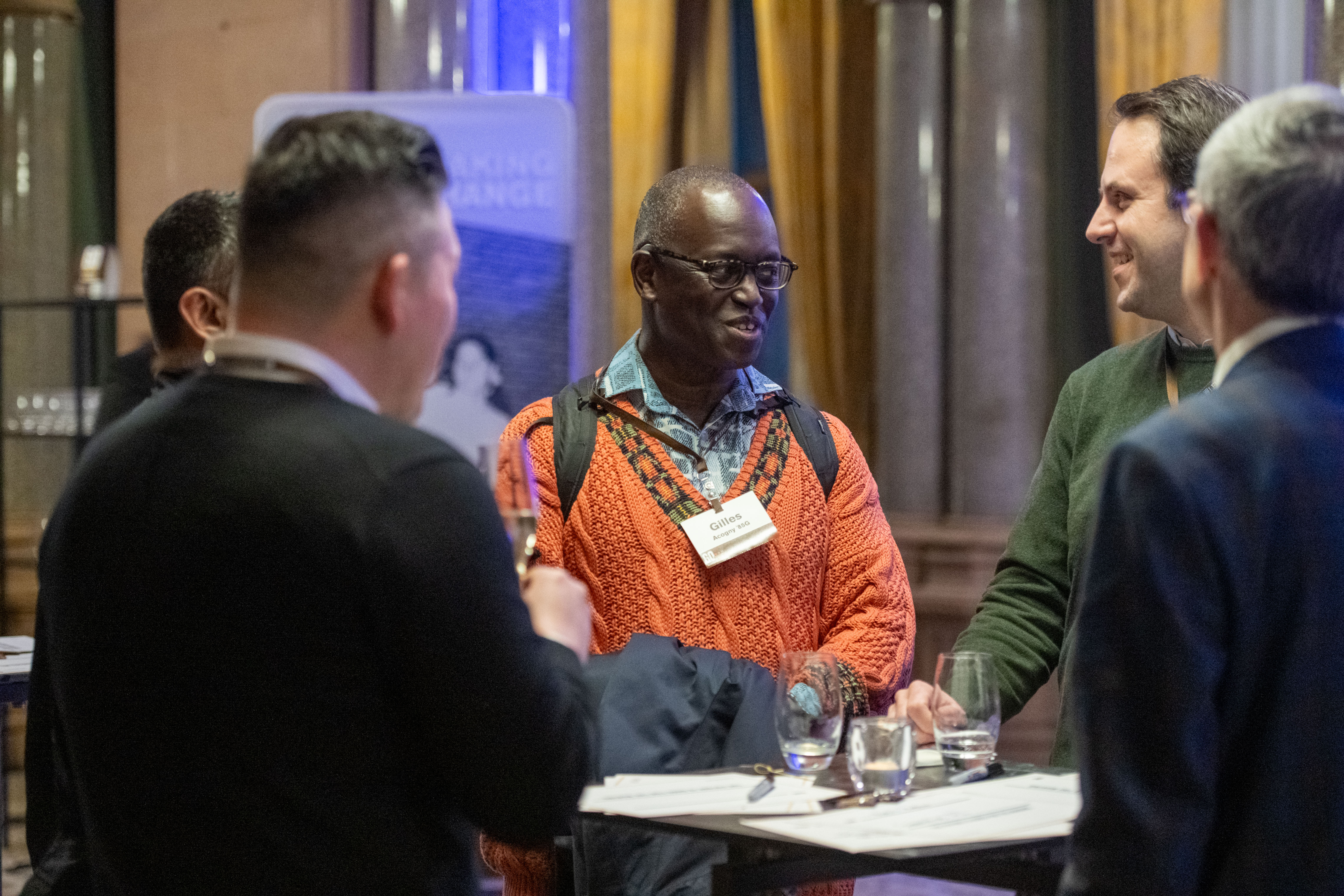 Gilles Amadou Acogny speaking to others at a networking event