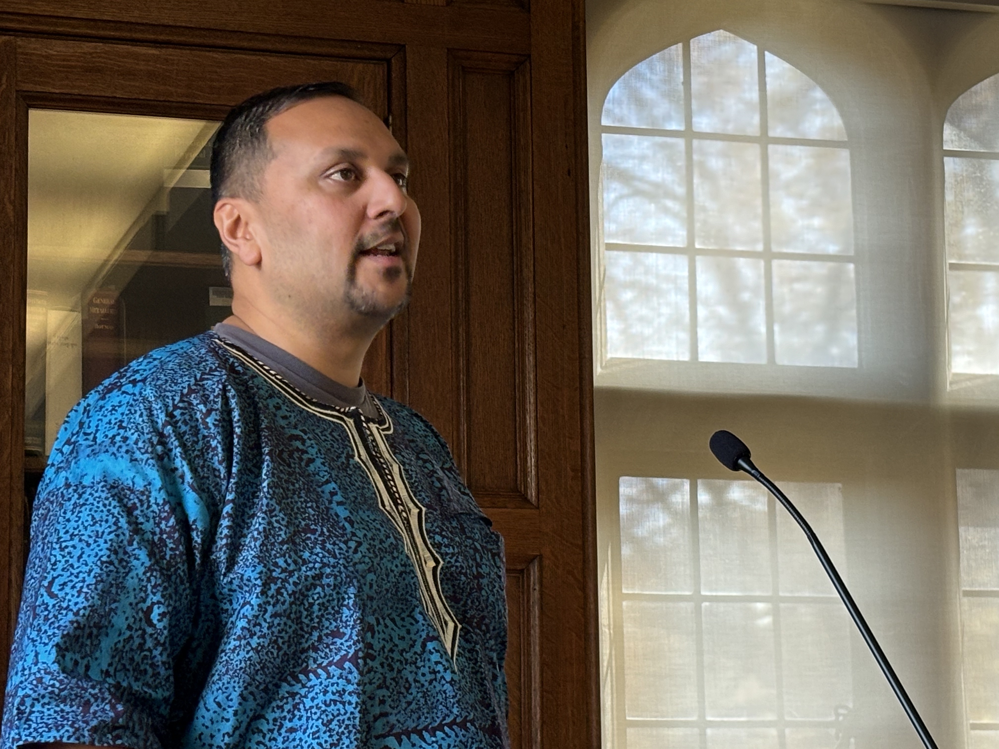 Amer Ahmed speaking at a podium