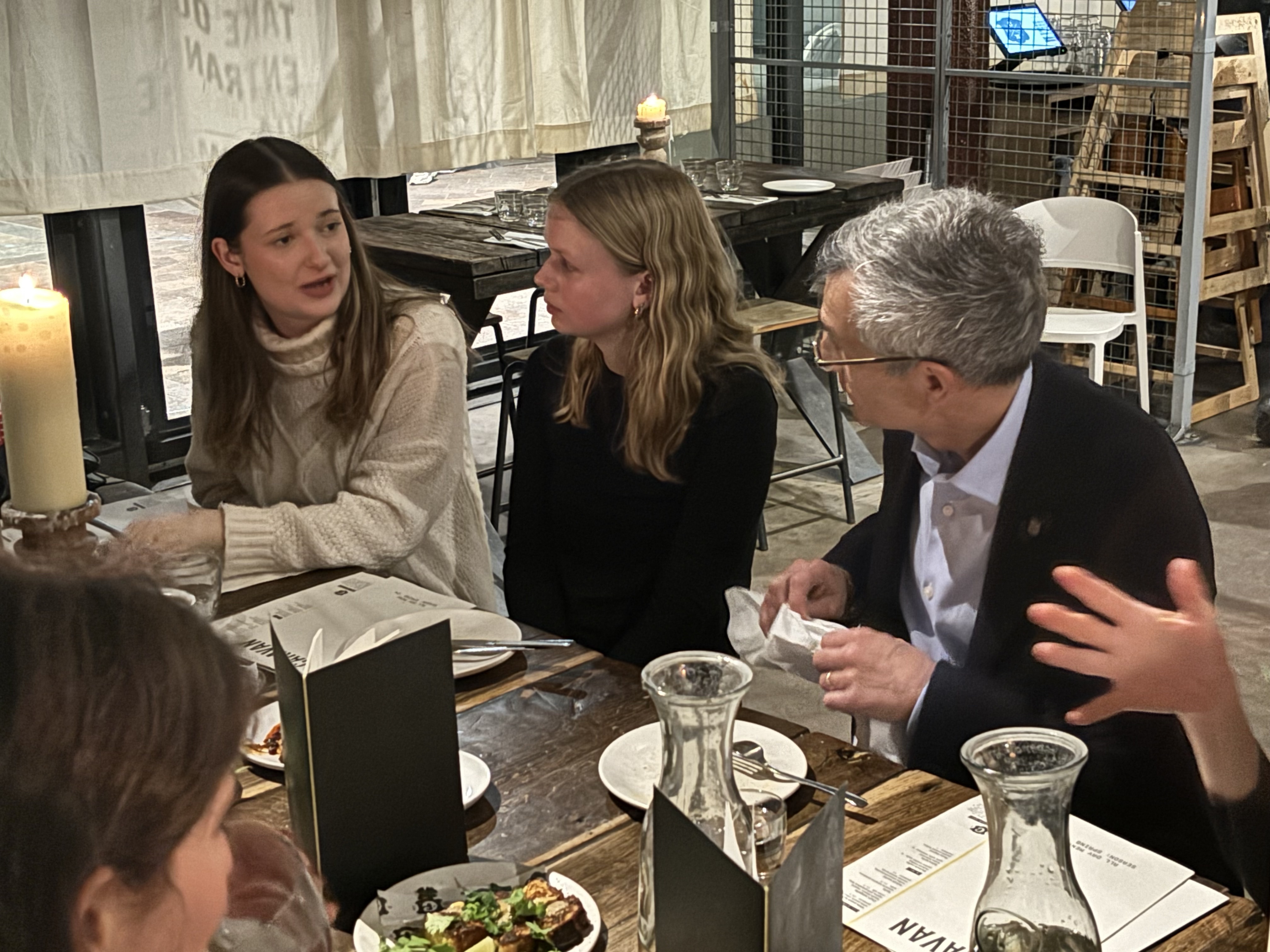 Two Lehigh University students speaking to Lehigh President Joseph Helble at dinner