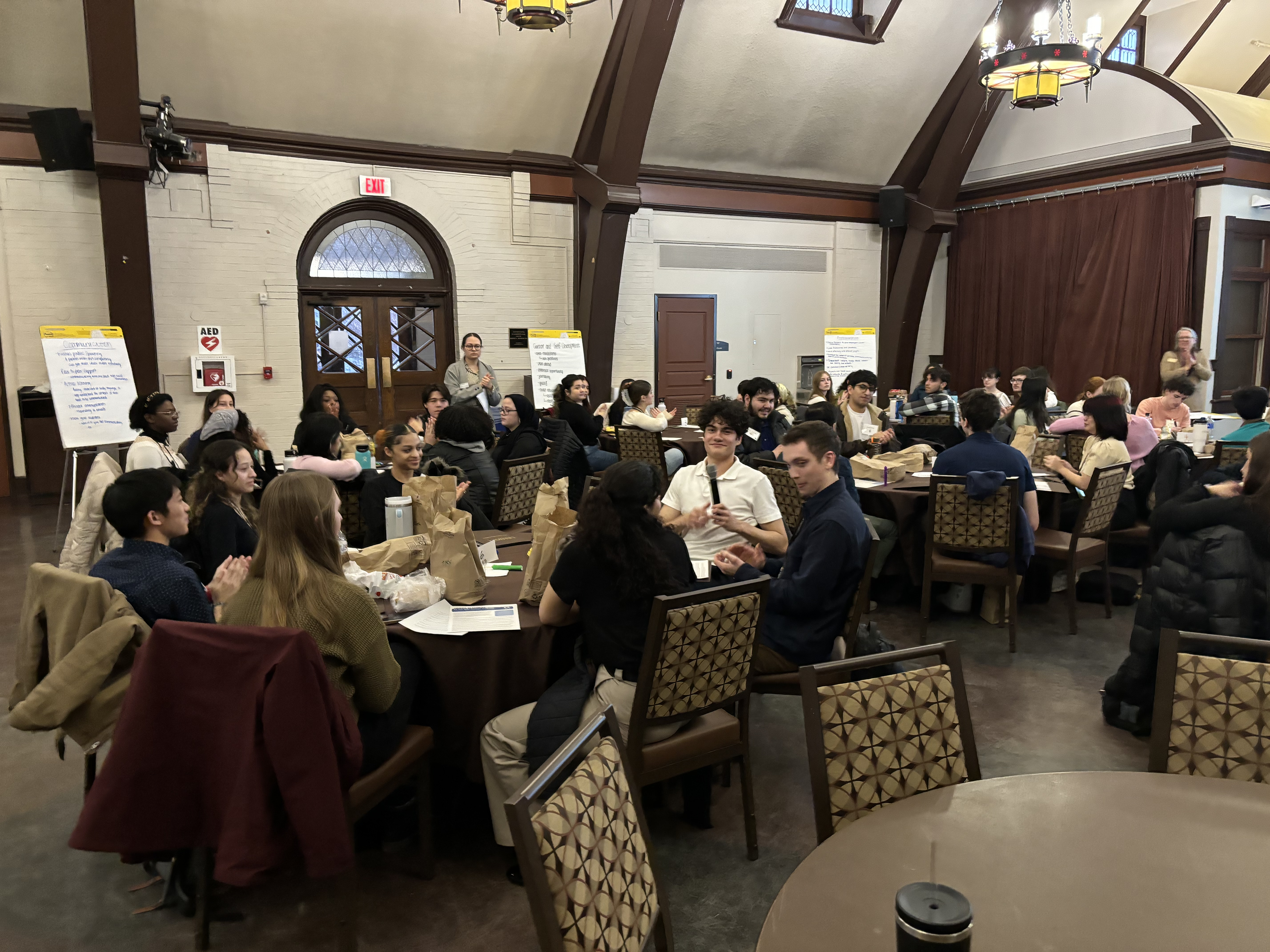 Lehigh University students seated at several round tables inside a large room