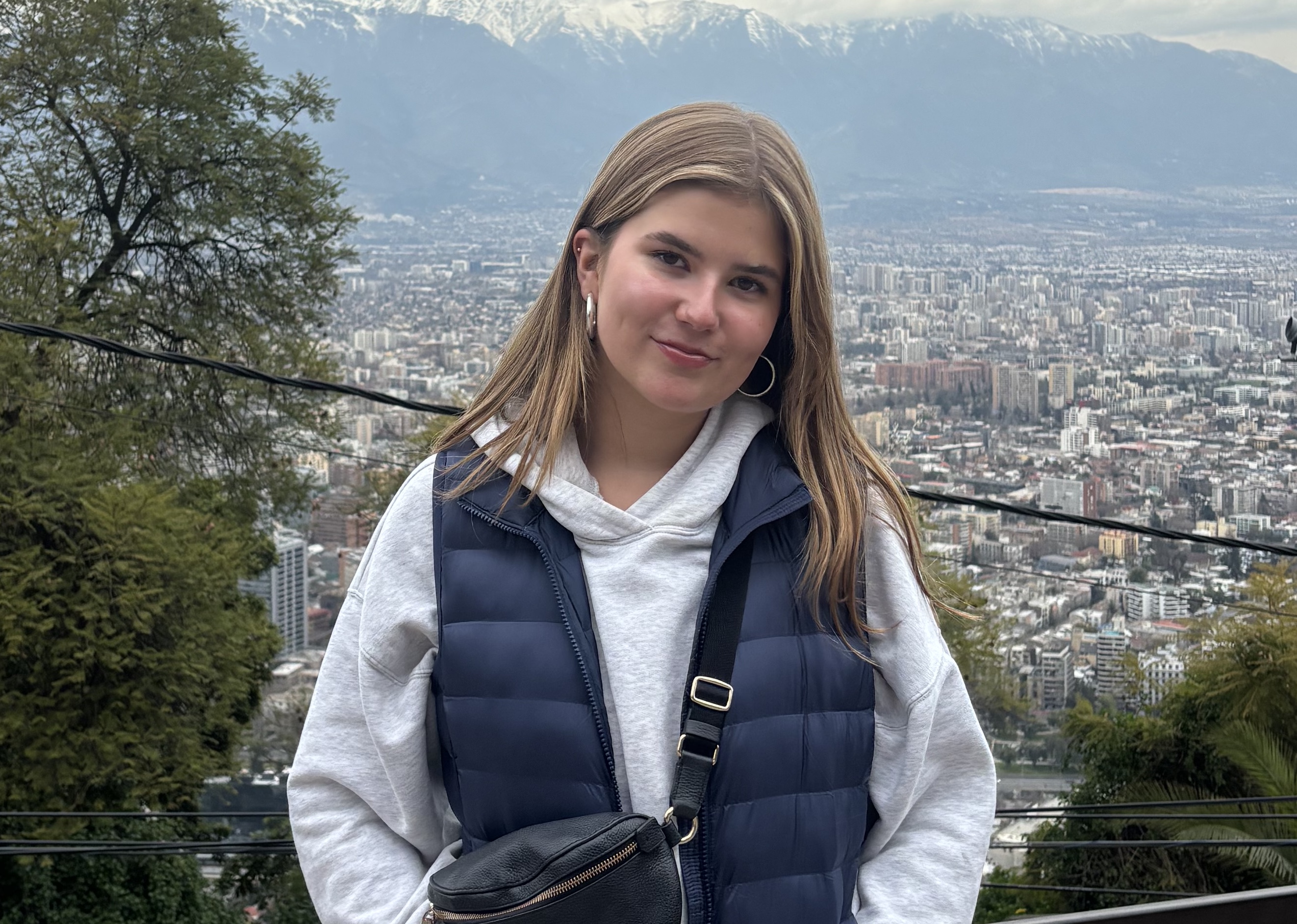 A young woman posing for a photo with Santiago, Chile in the background