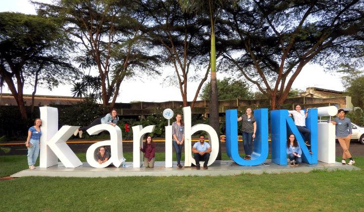 Students posing around a sign