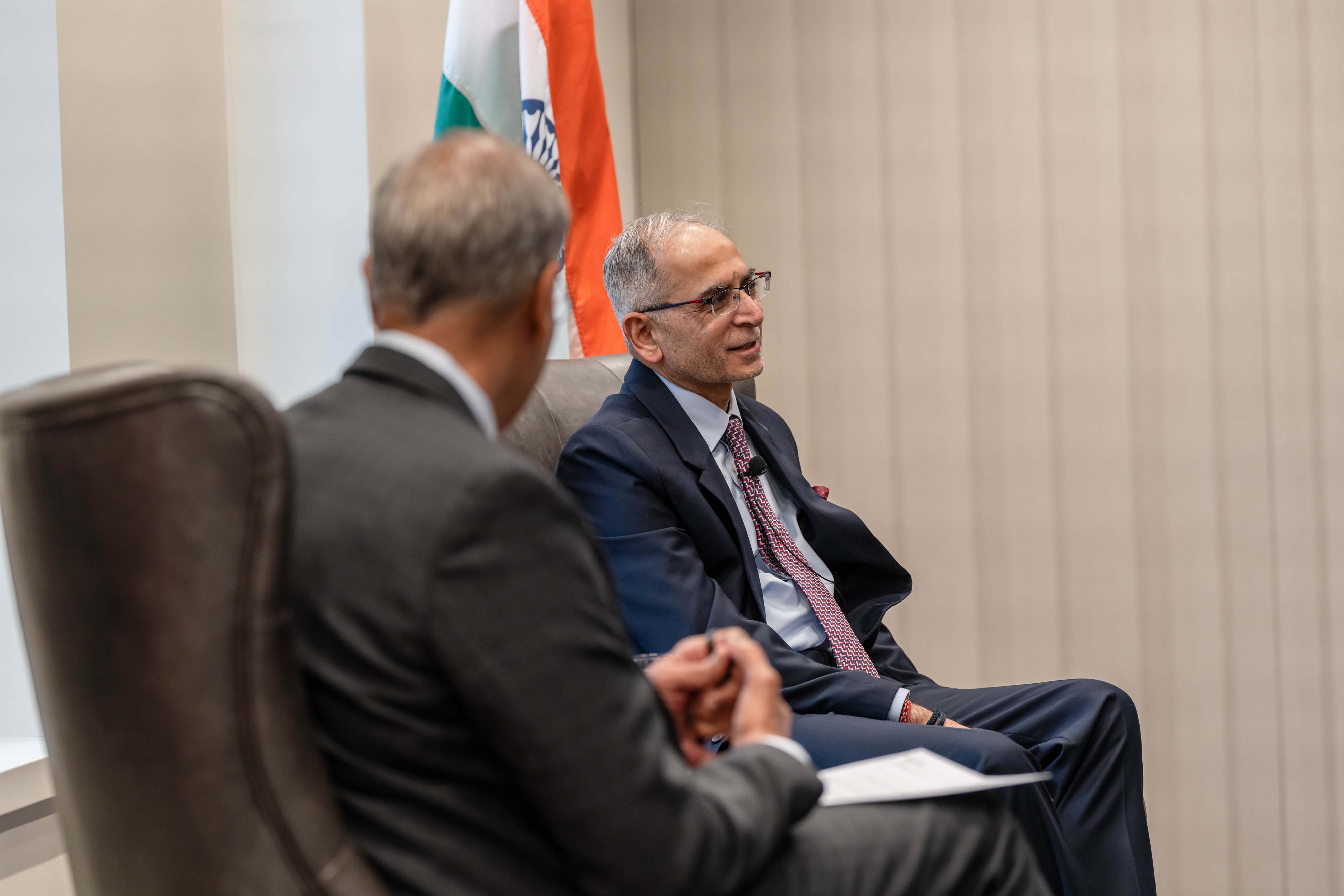 Two men sitting on chairs on a stage