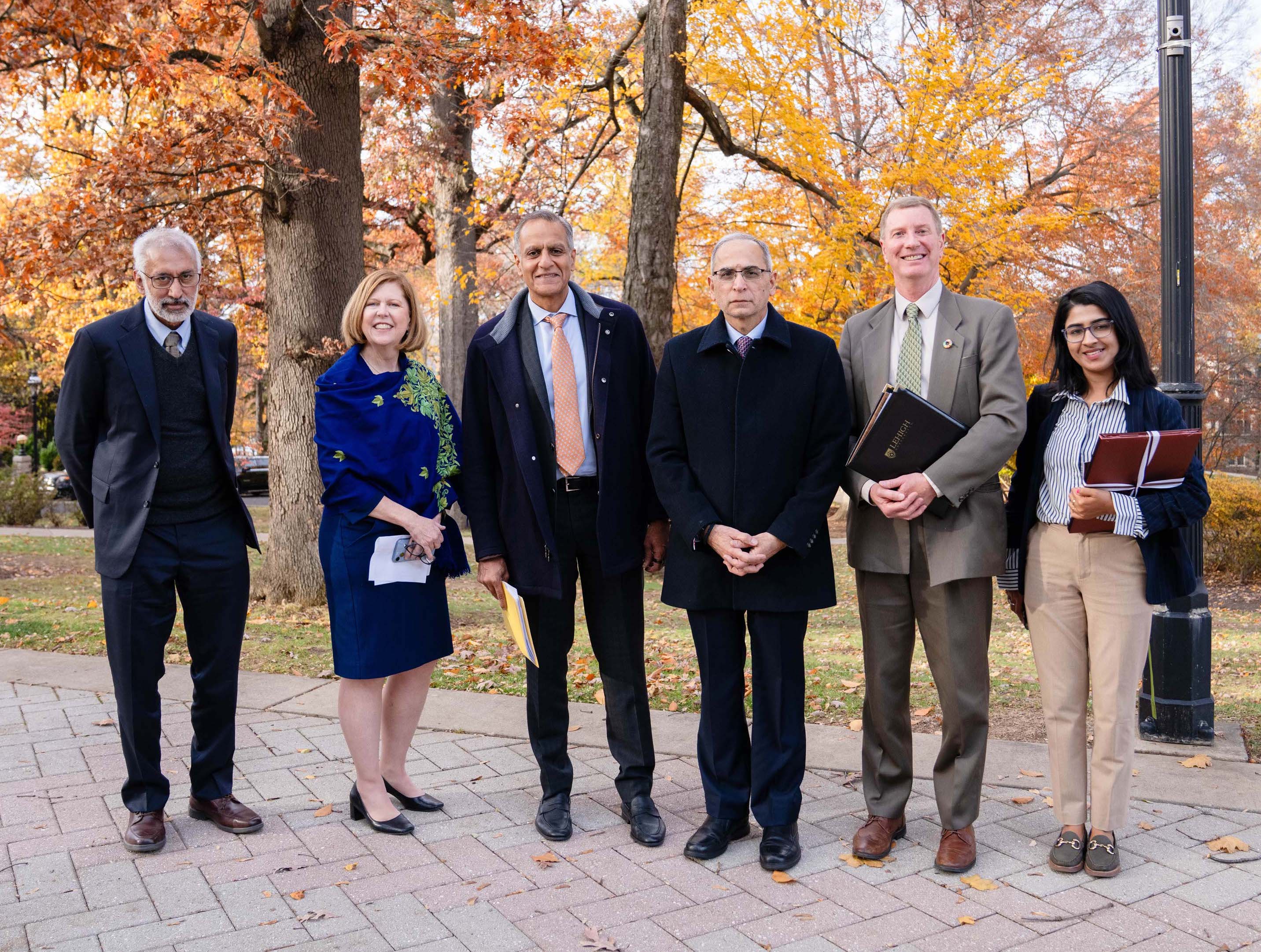 Six people smiling for the camera on a college campus