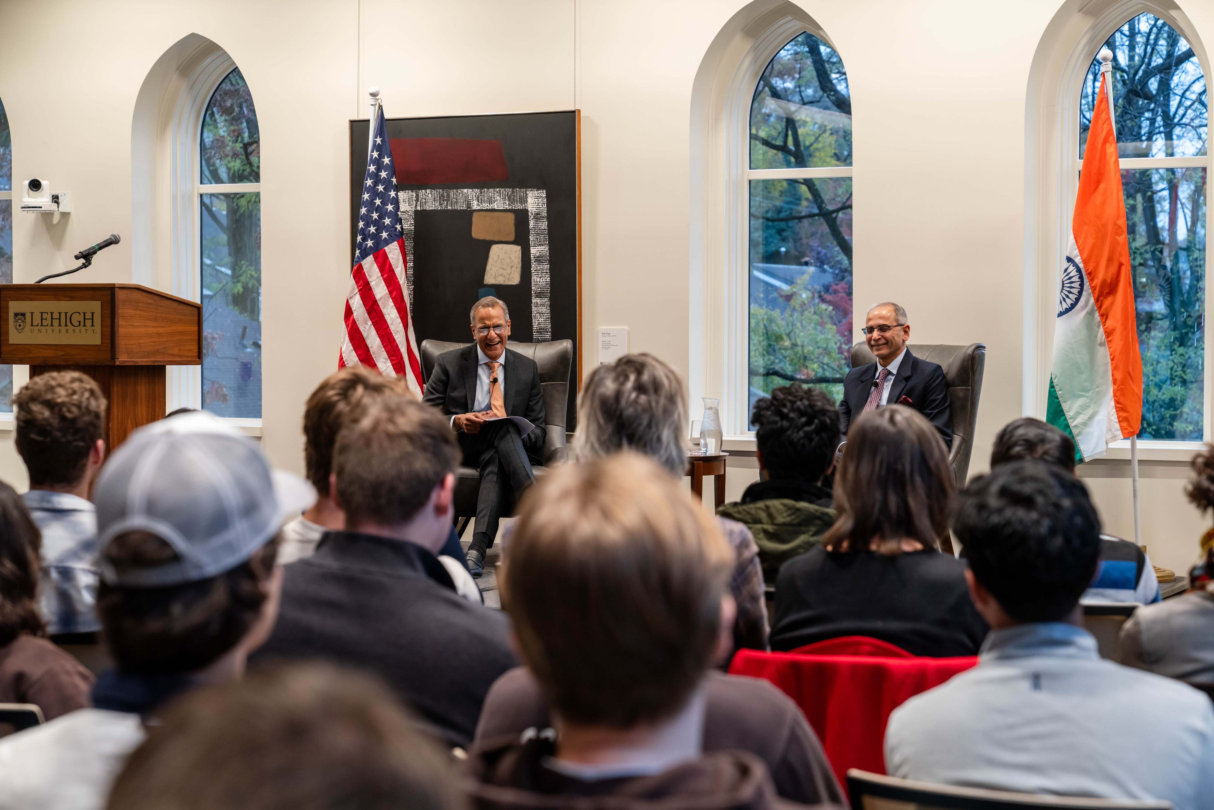 Two men sitting on chairs on a stage