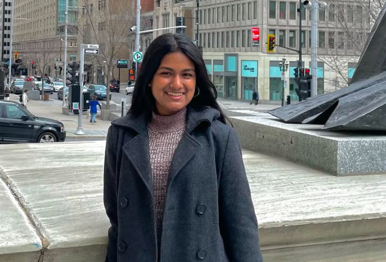 Anisha Dasgupta smiling for a photo in a city setting