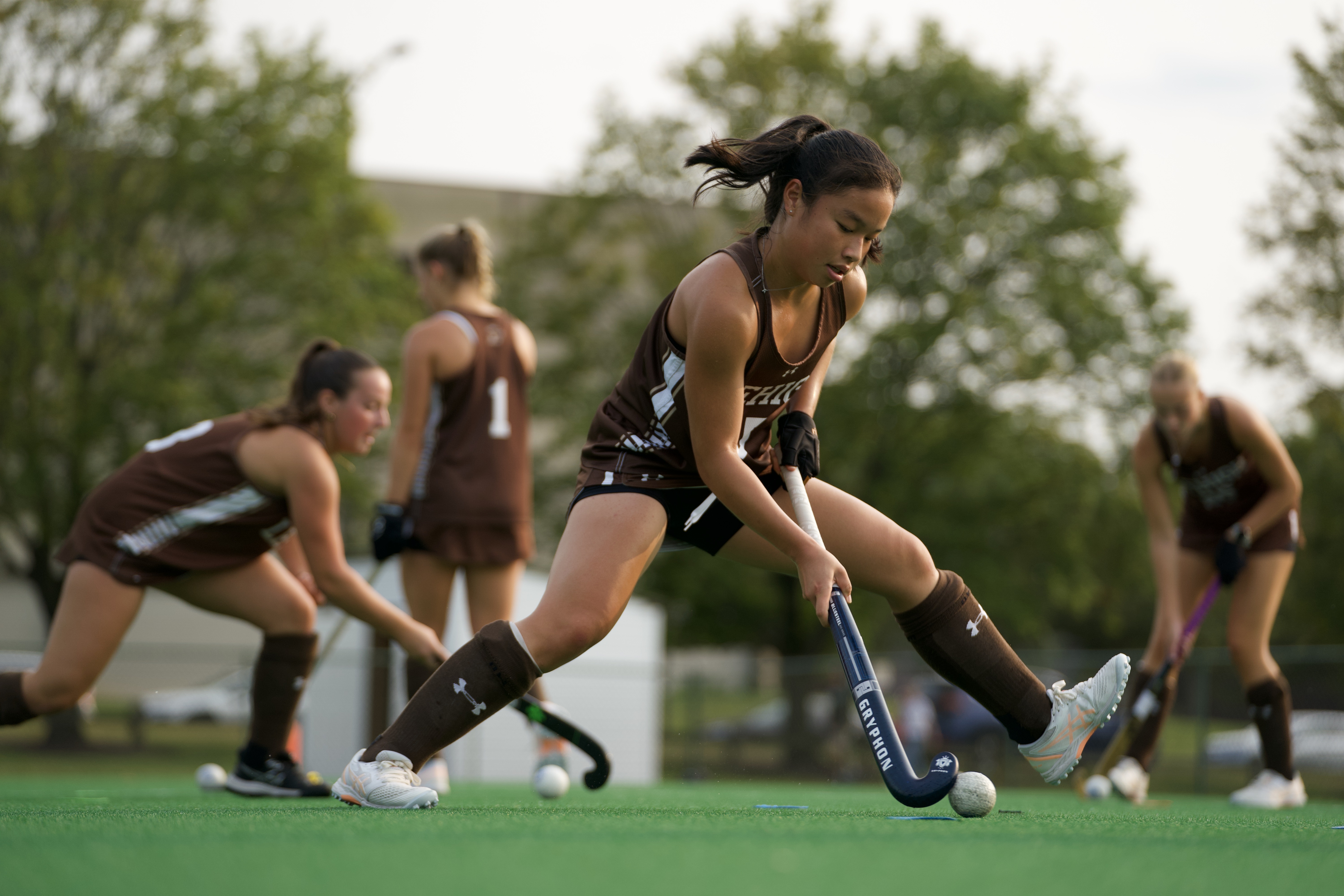 A young college student playing field hockey