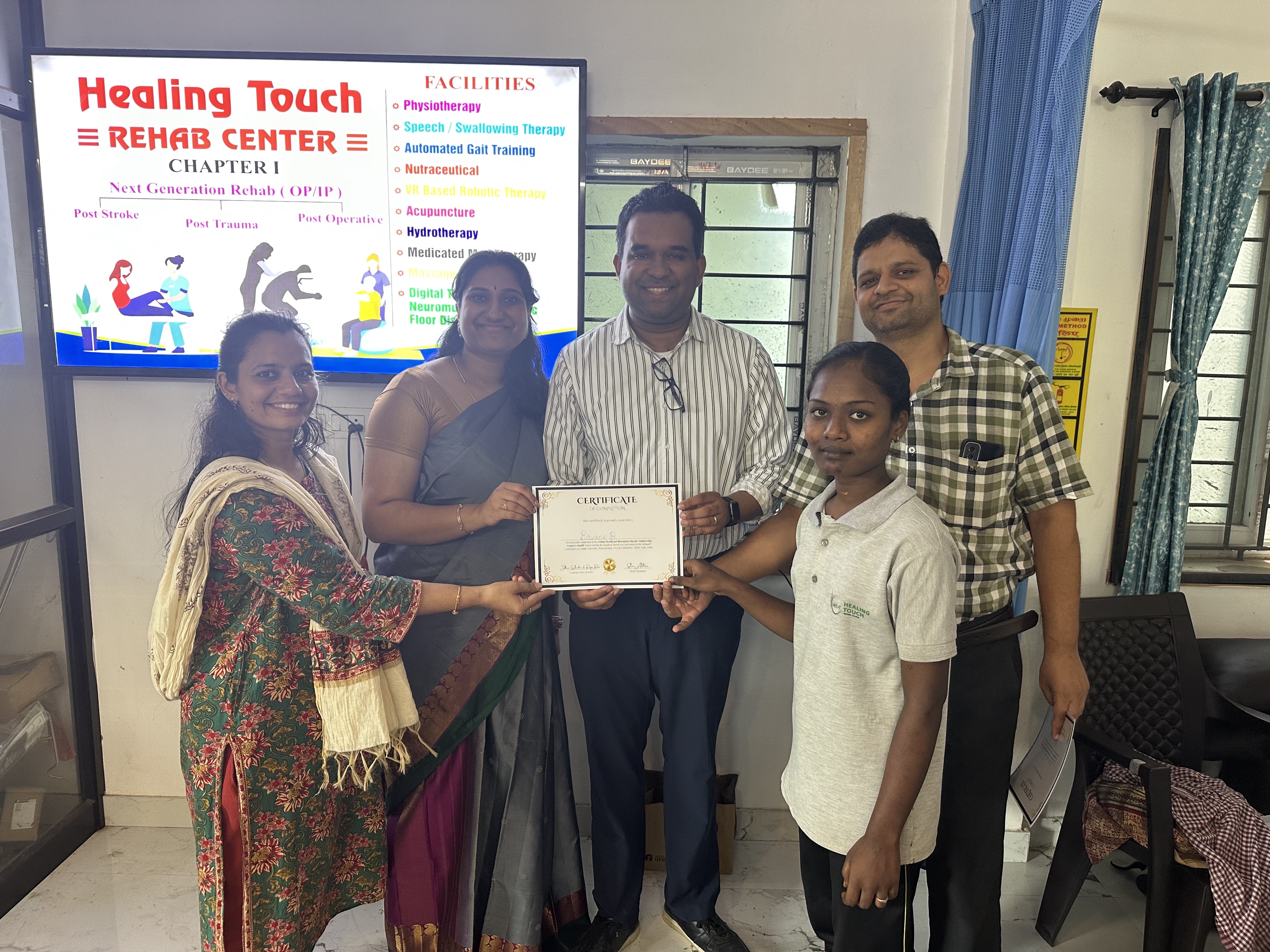 Five people posing for a photo with a certificate