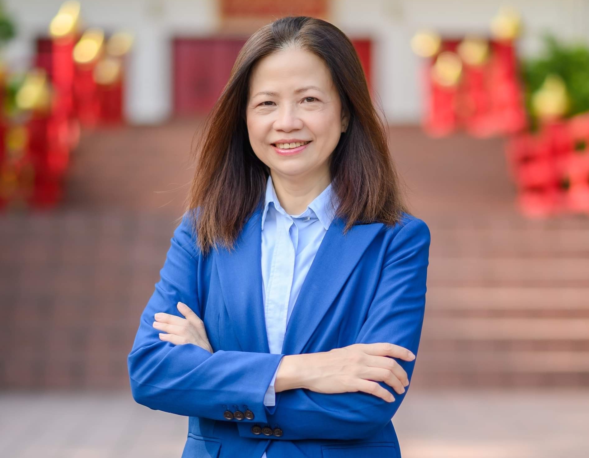 A woman in a blue suit jacket smiling for a photo