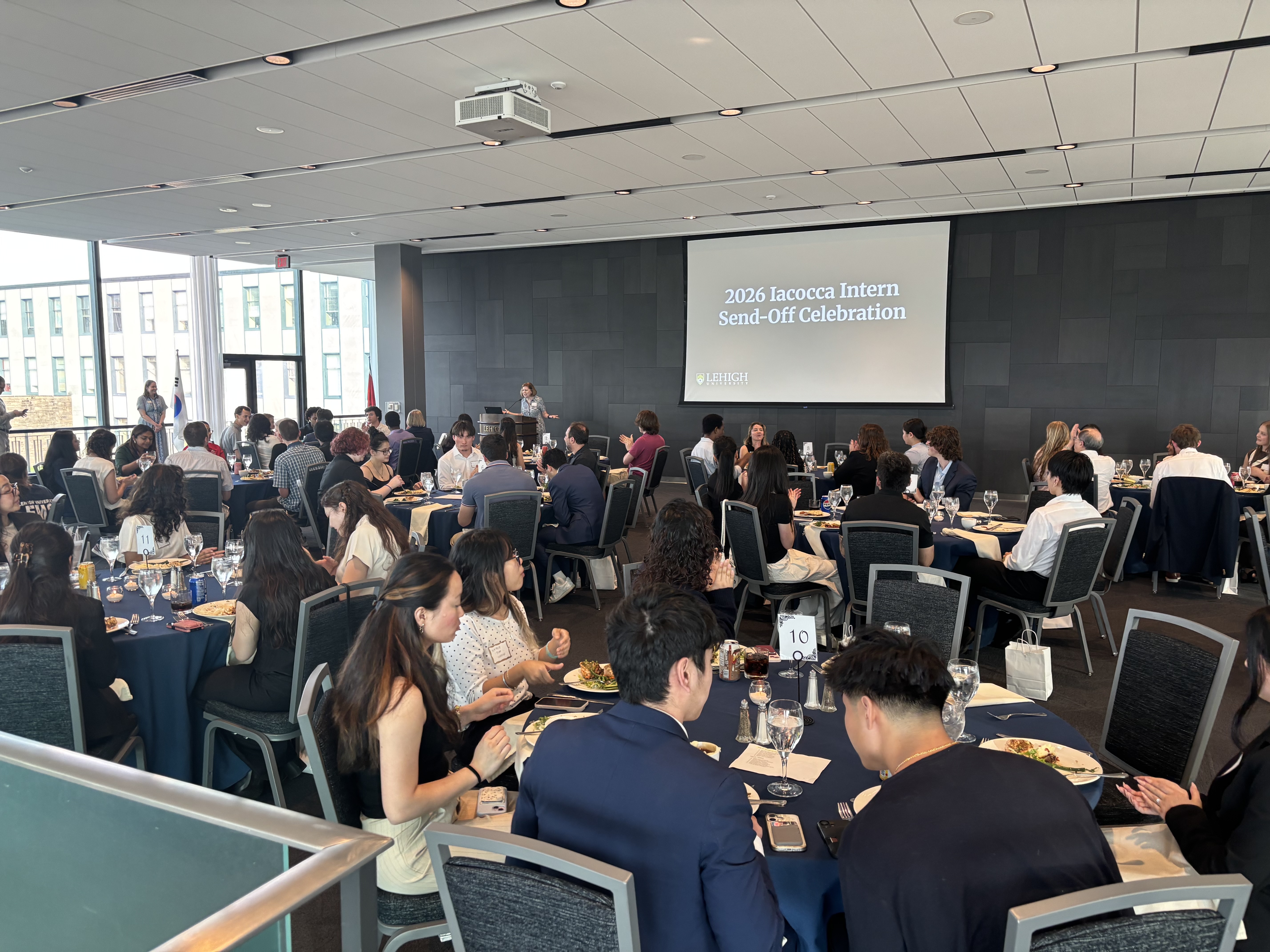 A group of people eating dinner at tables in a large conference room