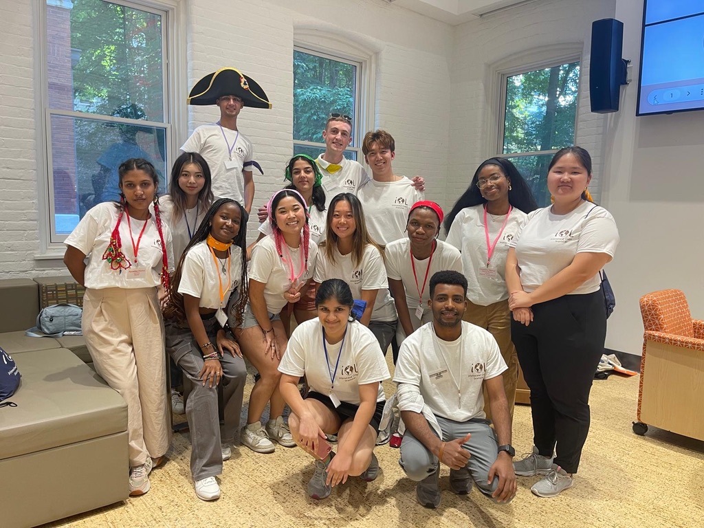 Several students in matching white shirts posing for a photo