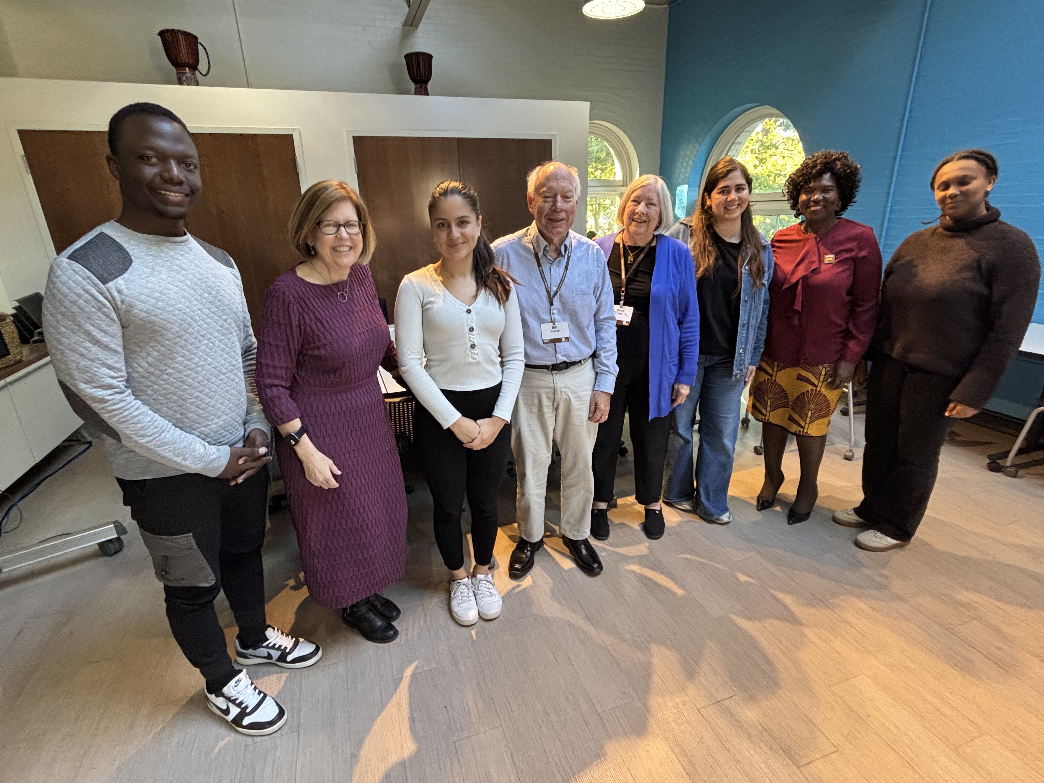 A group of people standing in a room, smiling for the camera
