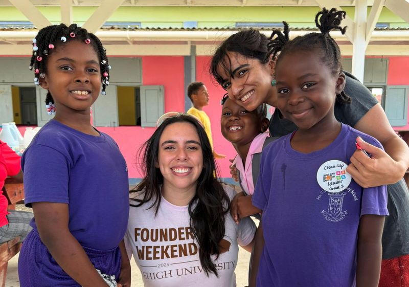 Two college students and three little girls smiling for a photo