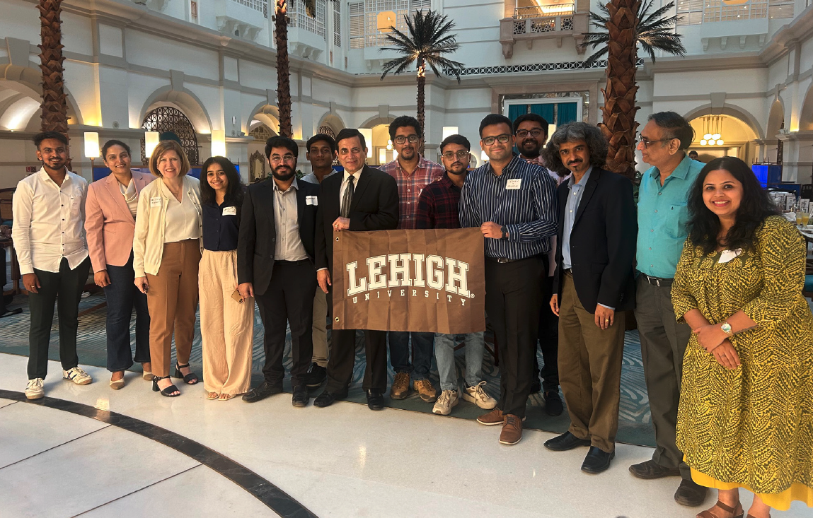 A group of people holding a Lehigh banner and smiling