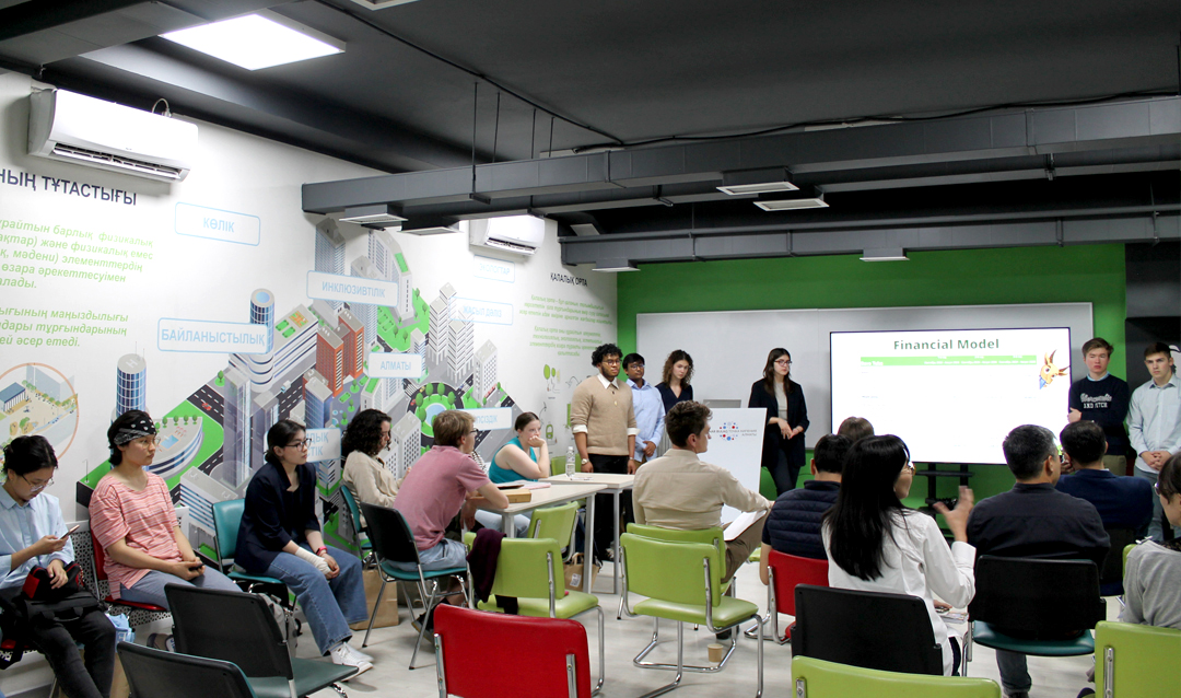 A group of students giving a presentation in a room to several seated people