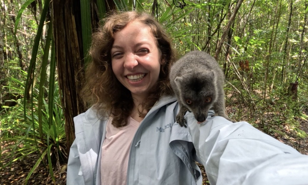 Liz Matthews with an animal on her arm in a jungle