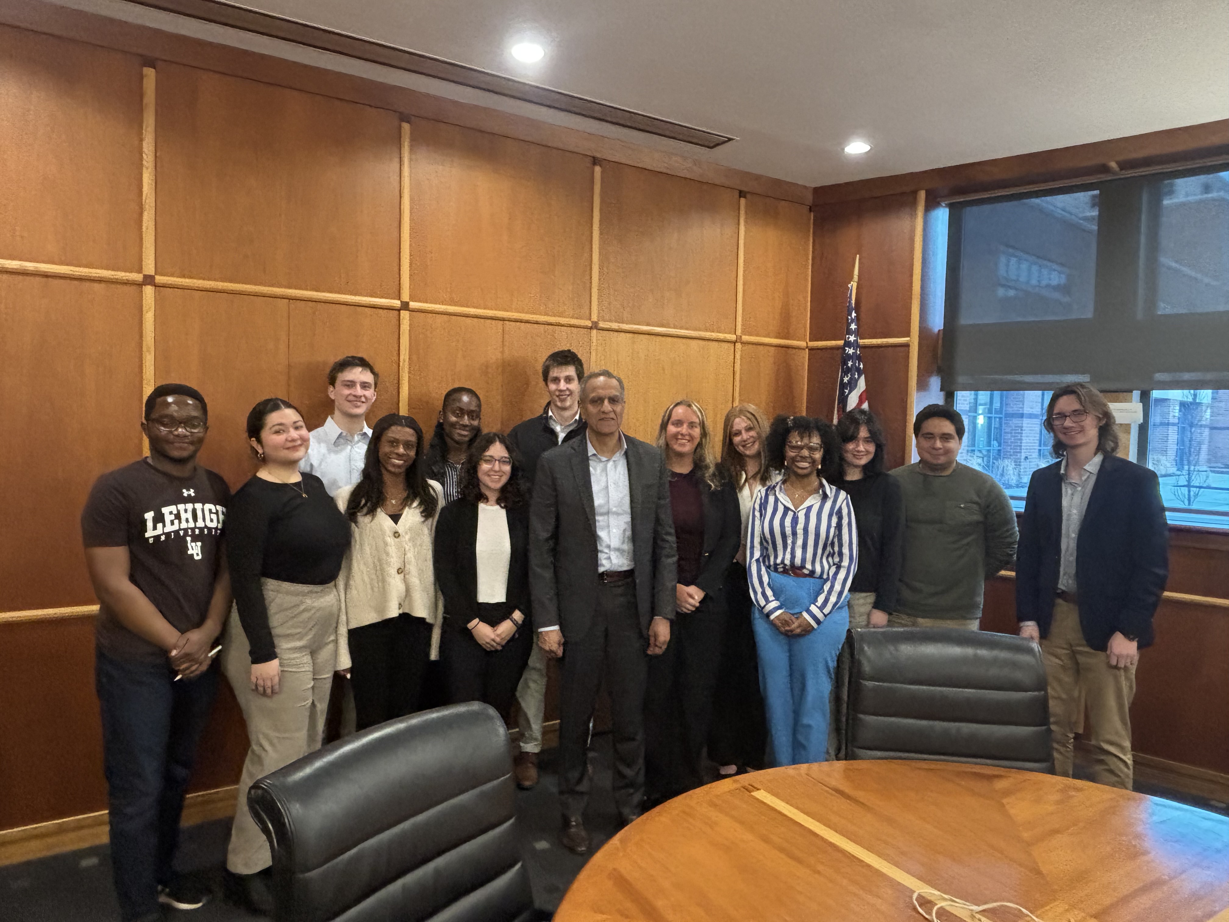 Richard Verma standing with several Lehigh University students in a meeting room