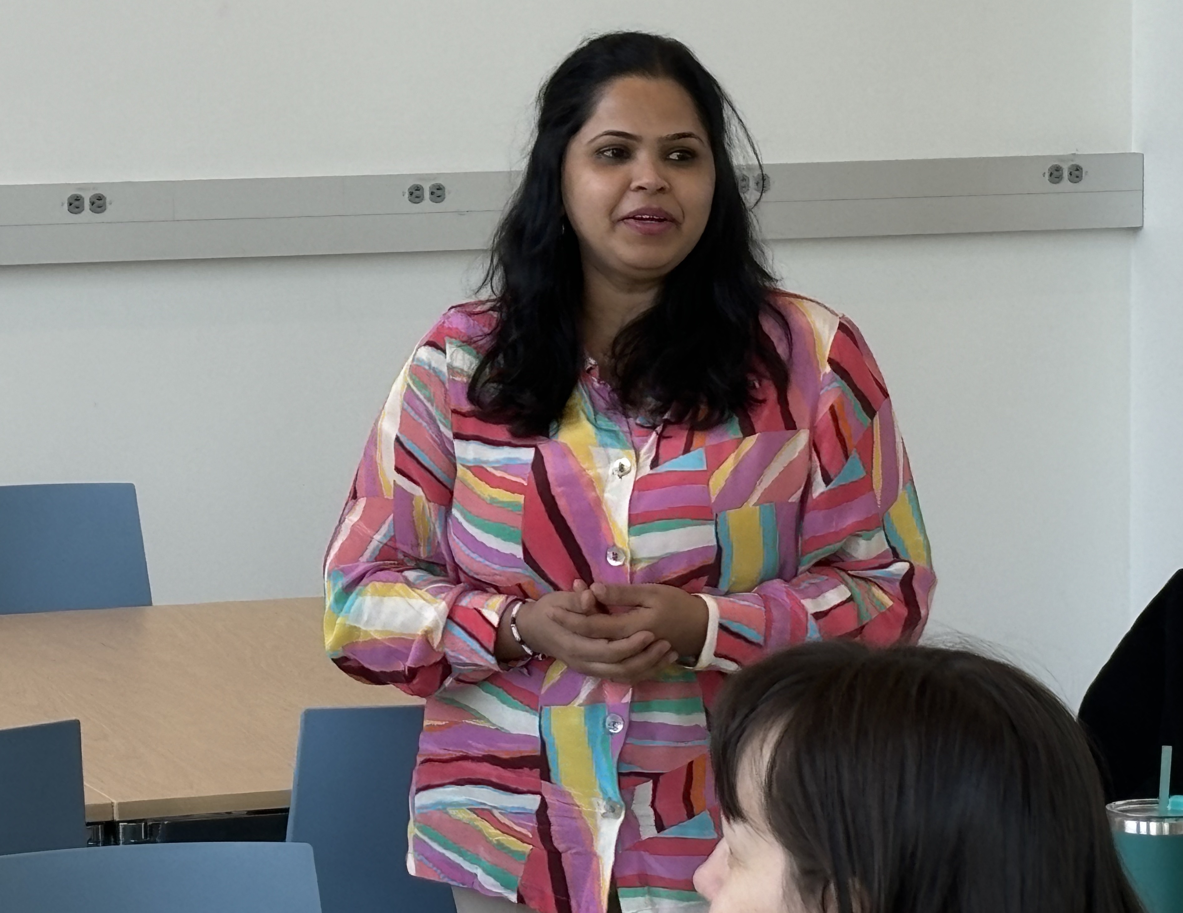 Vinita Desai talking to a group of people who are off-camera