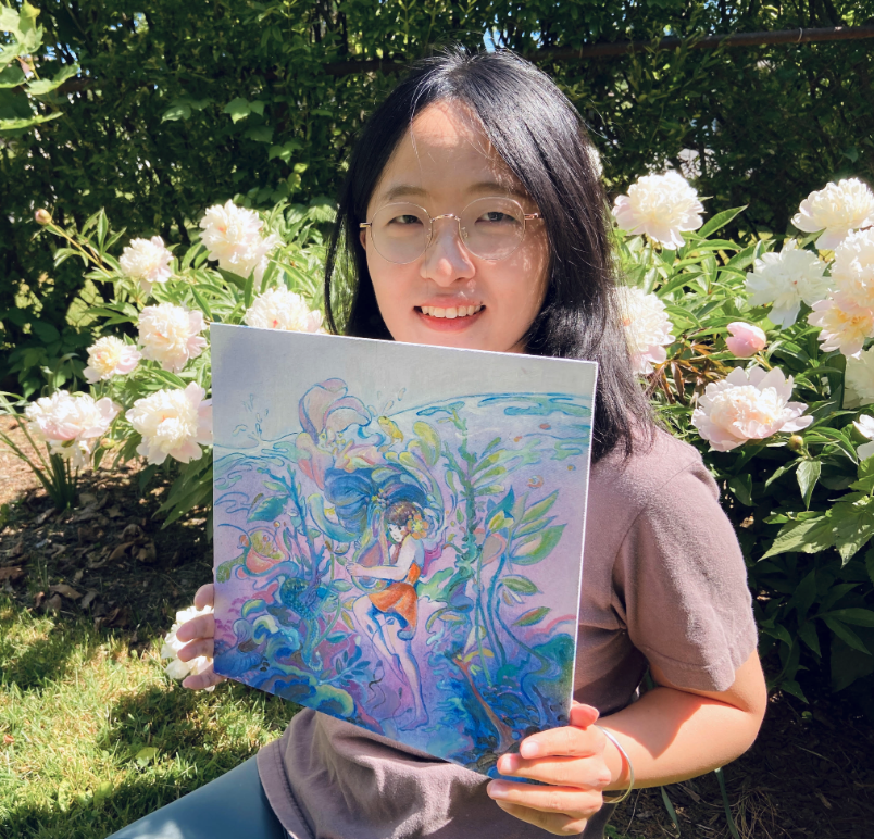 A young woman holding a painting