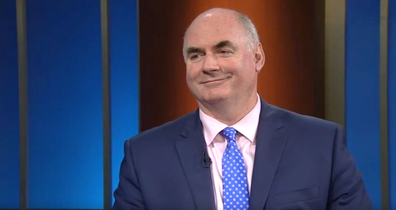 kevin cassidy in a dark blue suit with a light pink shirt