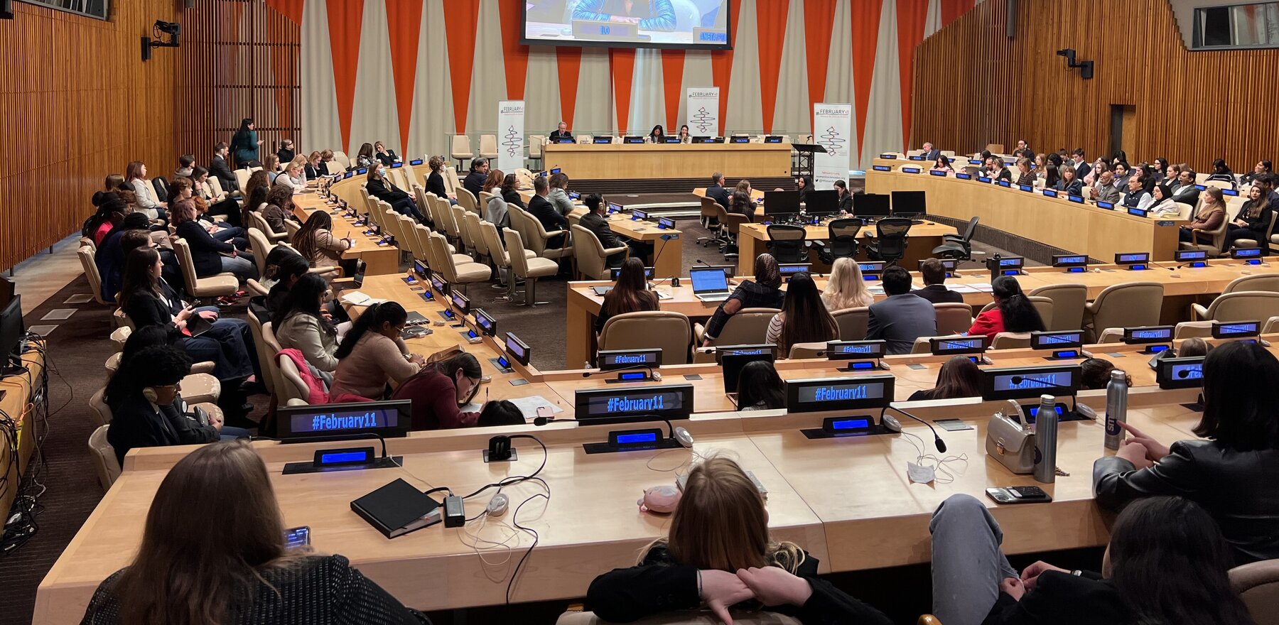 A group of people listening to a speaker at the United Nations headquarters