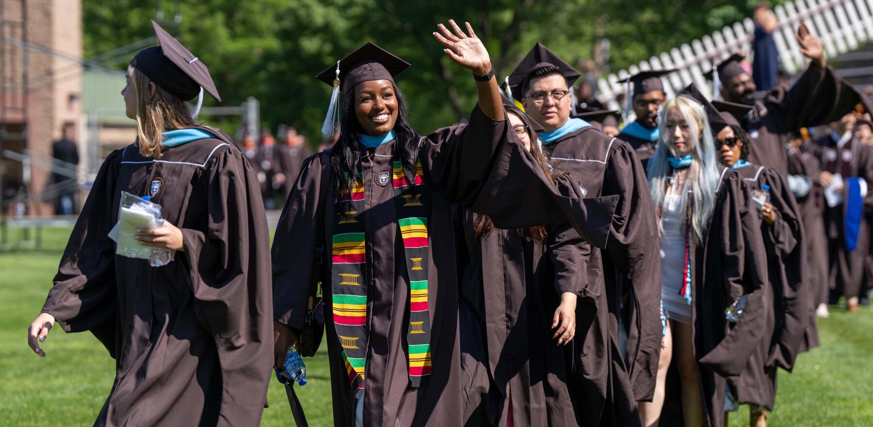 Students walking outside in graduation robes