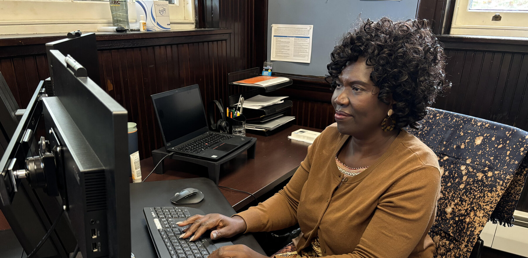 Asenath Asha Lutabingwa working at her computer