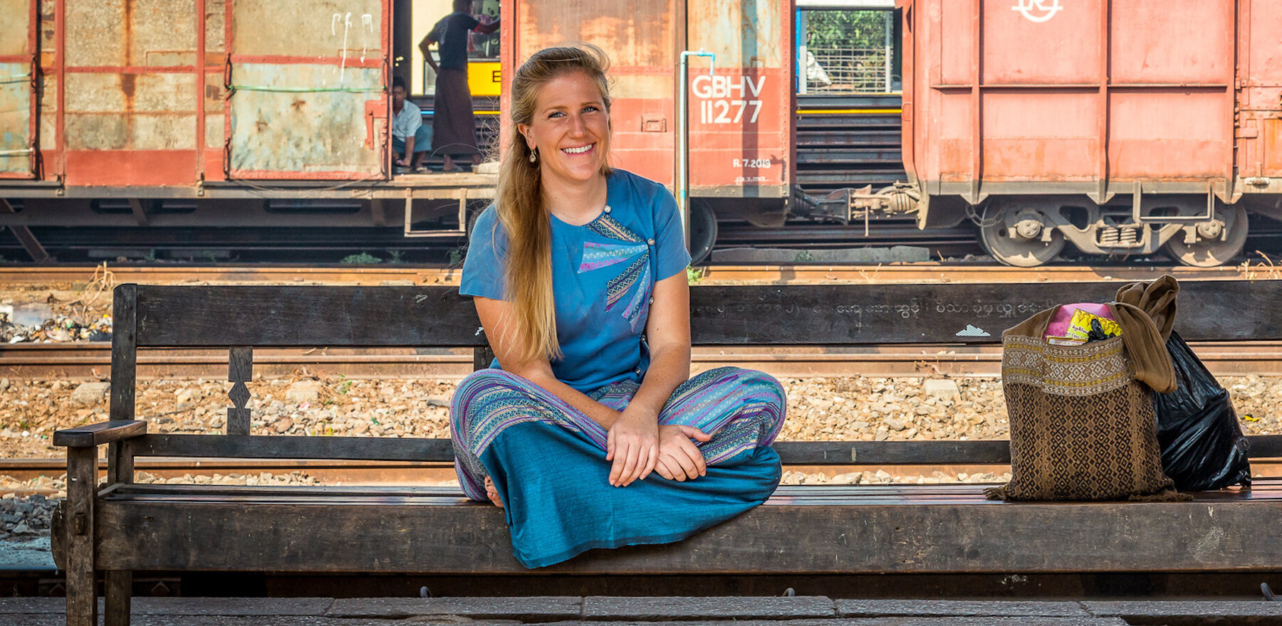 A woman in a blue dress at a train station in Myanmar