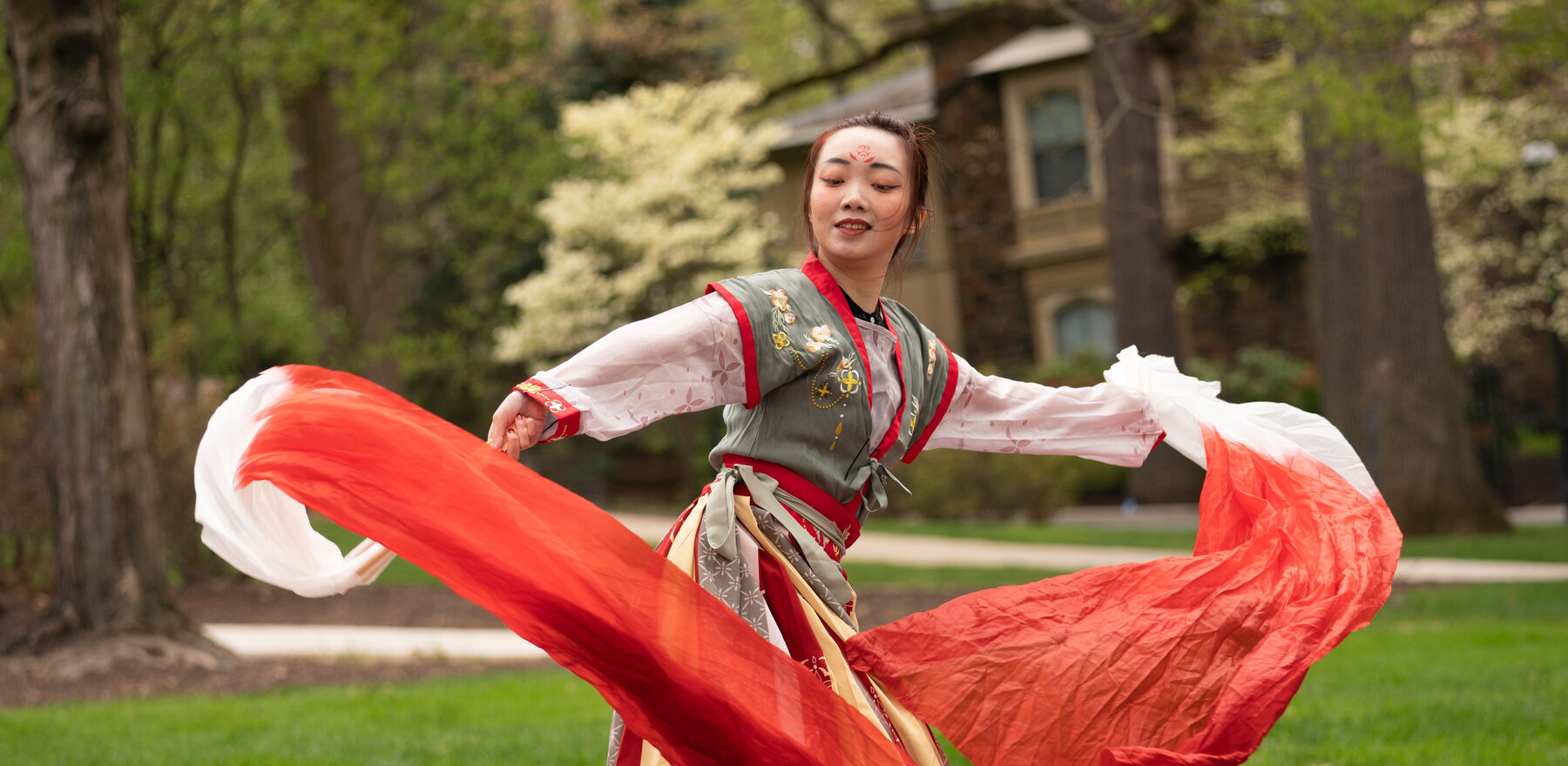 A young woman dancing on a college campus