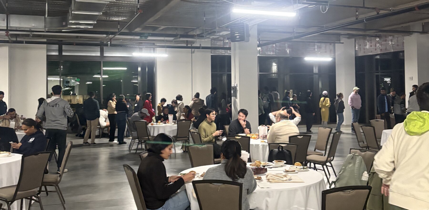 A group of people having dinner at various tables in a large room