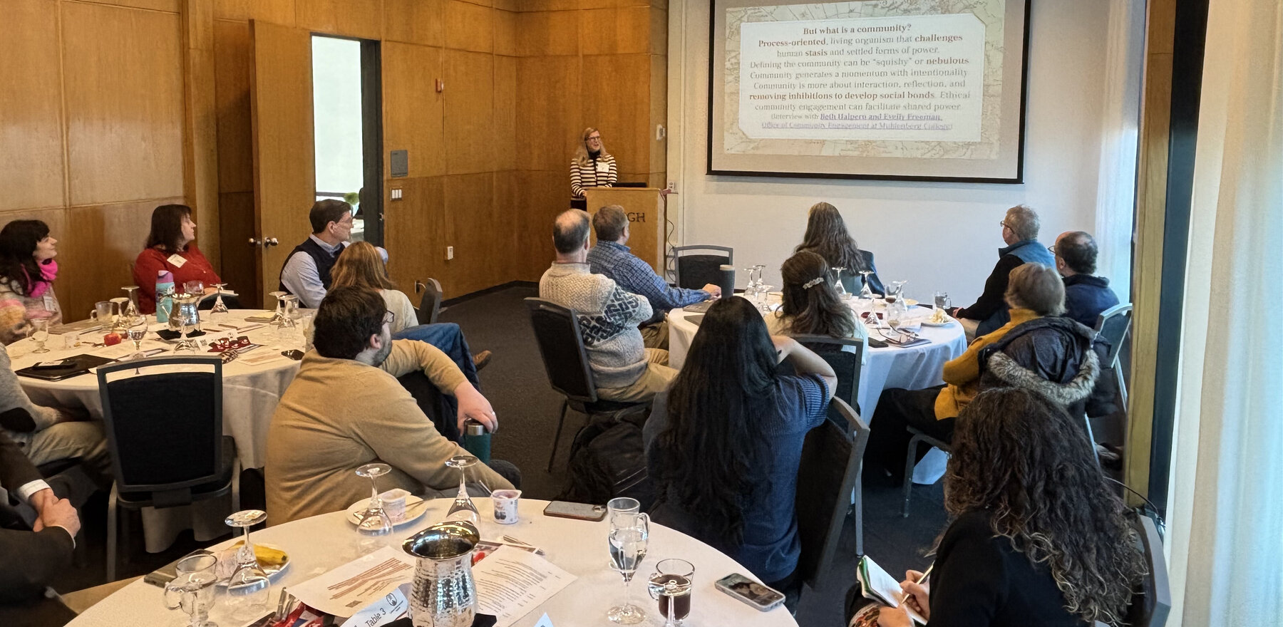 A group of people sitting at tables in a meeting