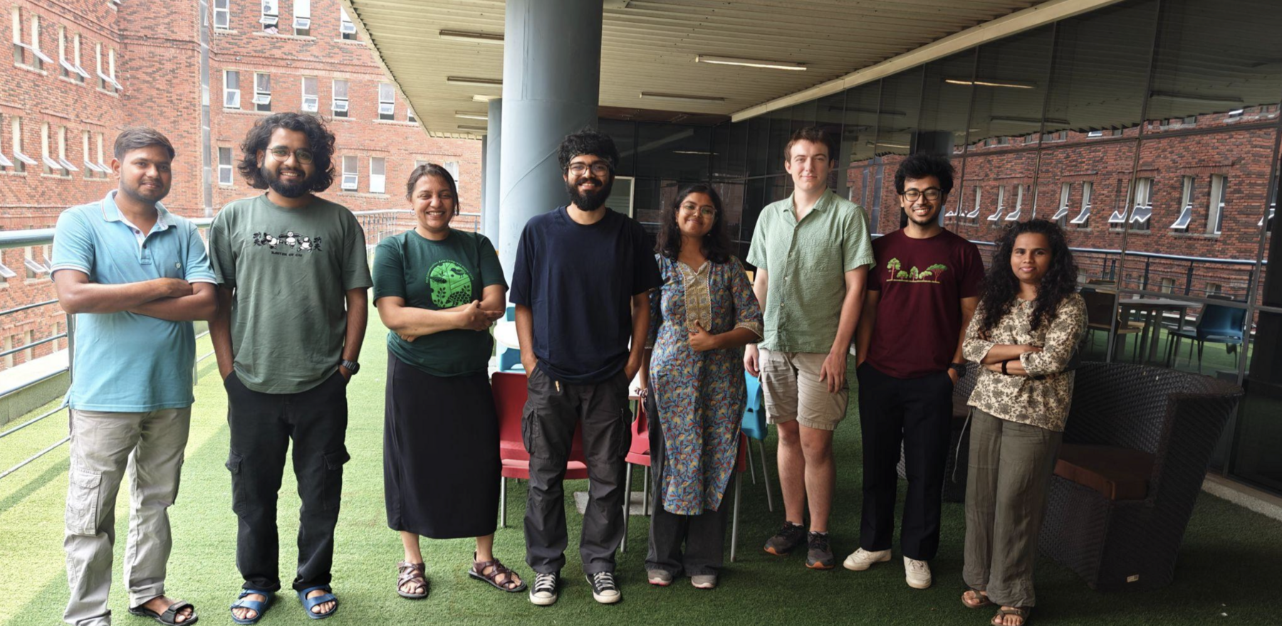 A group of people standing outside a building posing for a photo