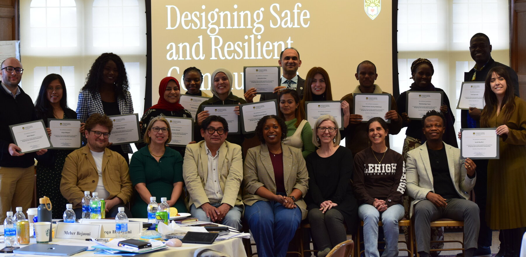 A group of people posing for a photo in front of a screen