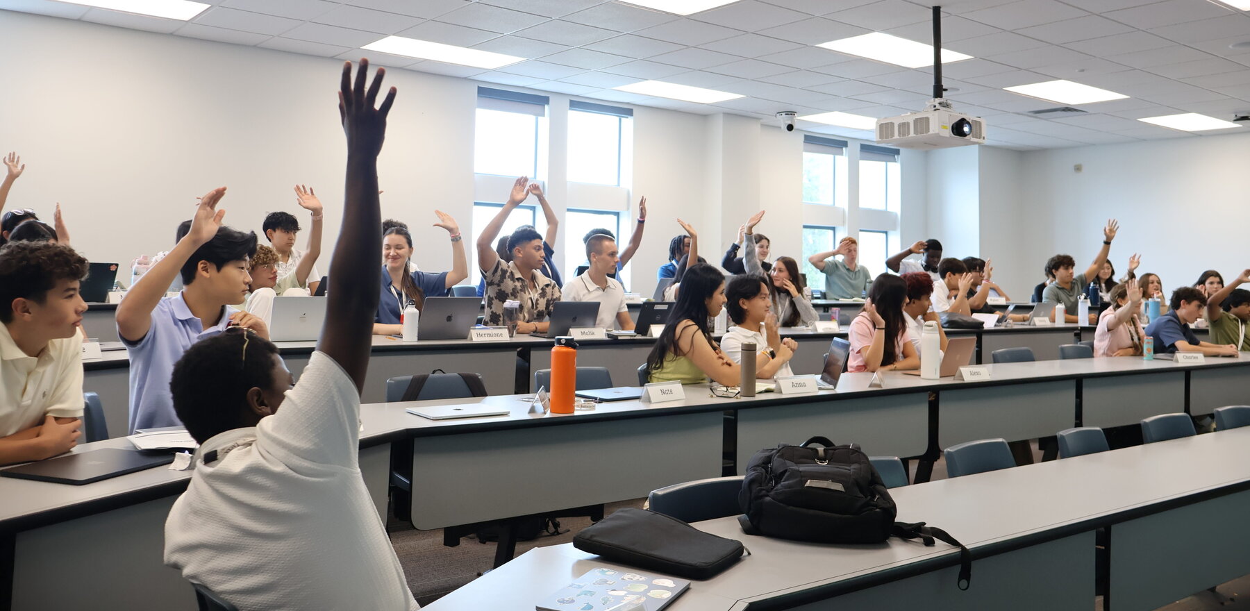 Students raising their hands in a classroom