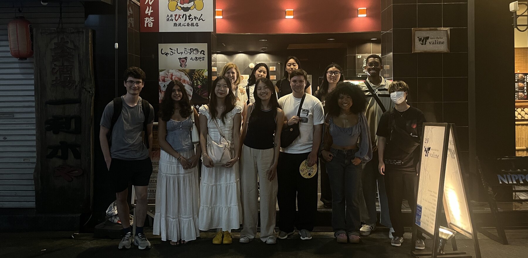 A group of students standing outside a restaurant