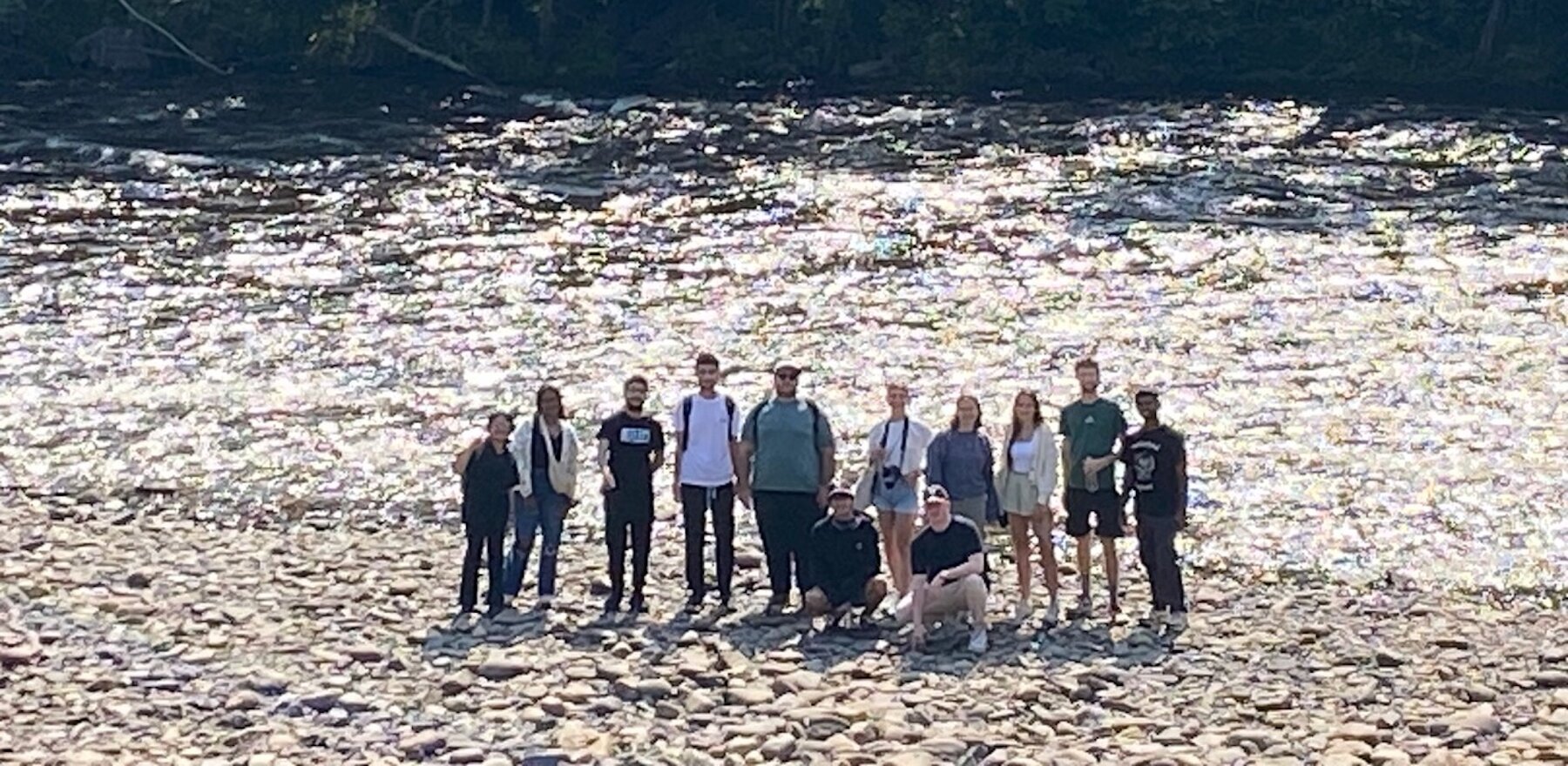 A group of people standing in front of a river