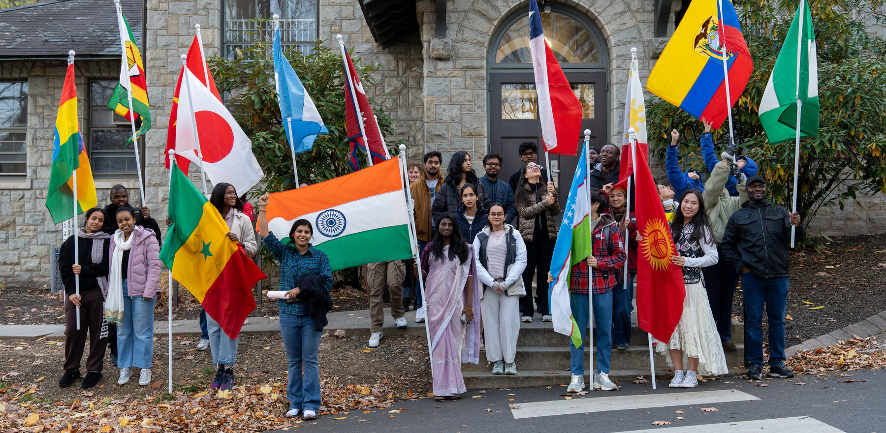 A group of students holding flags in front of a building