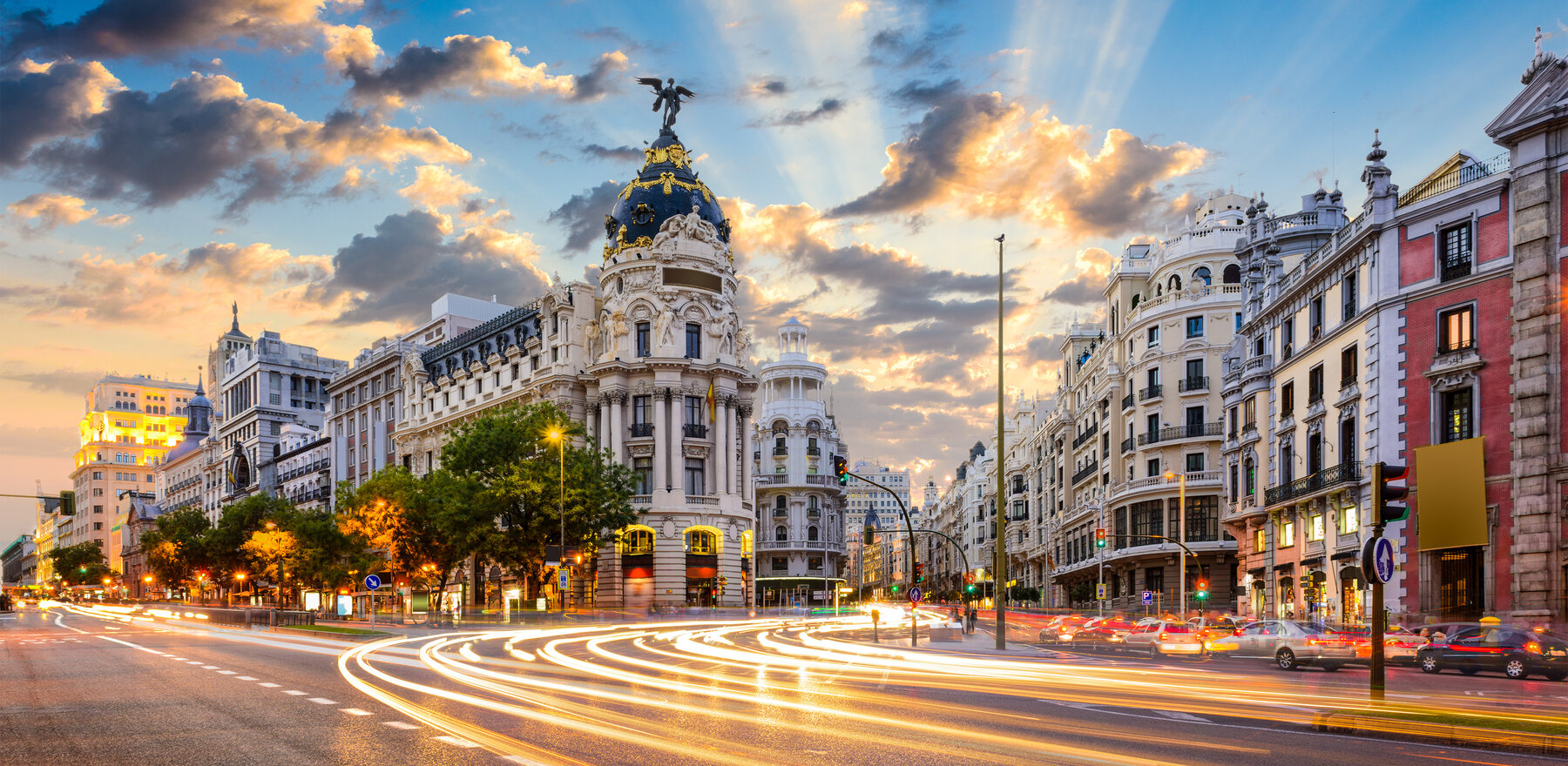 A time-lapse photo of Madrid buildings with the sun setting in the background