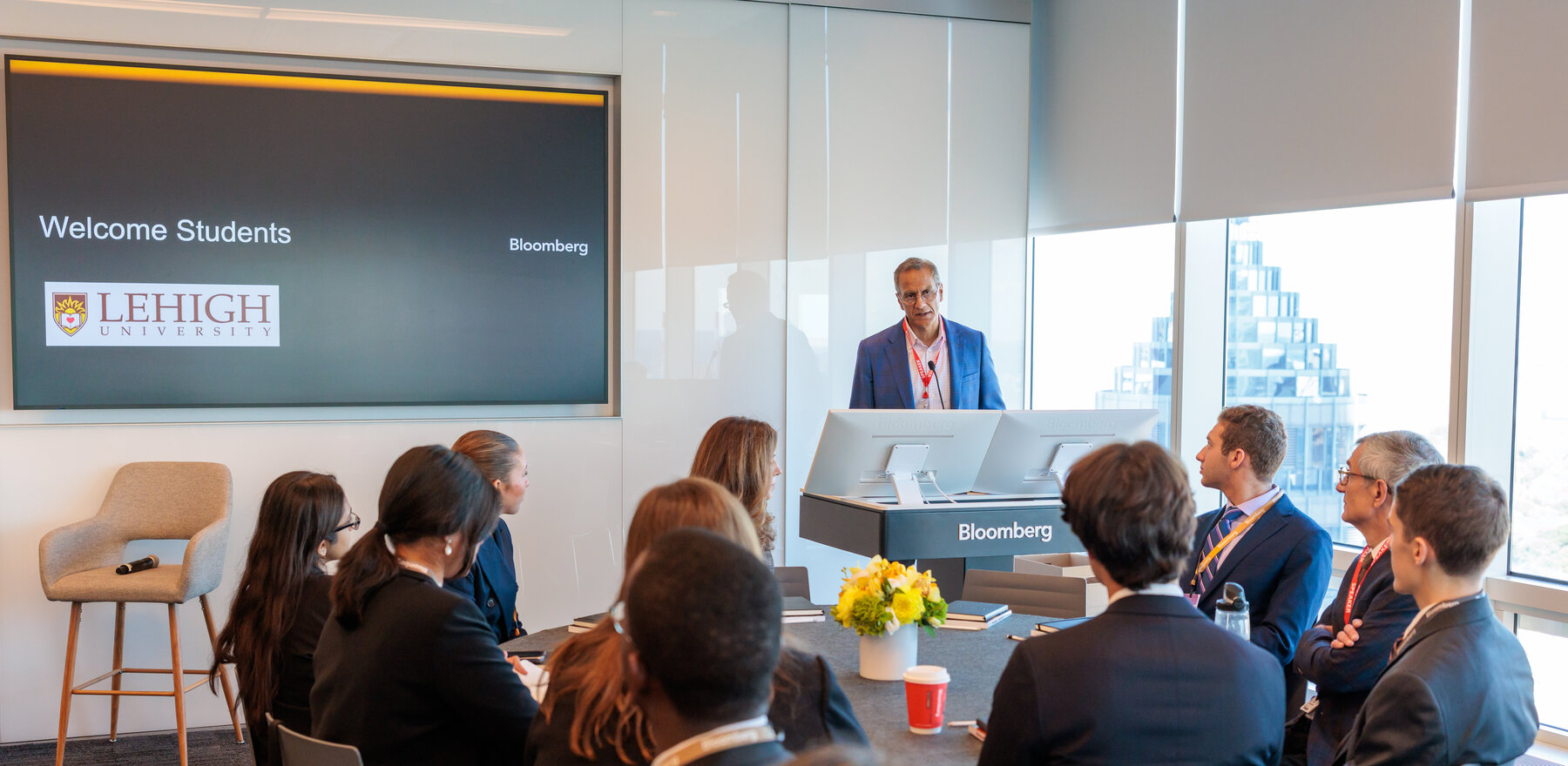 A man talks to a crowd from a podium at Bloomberg Tower