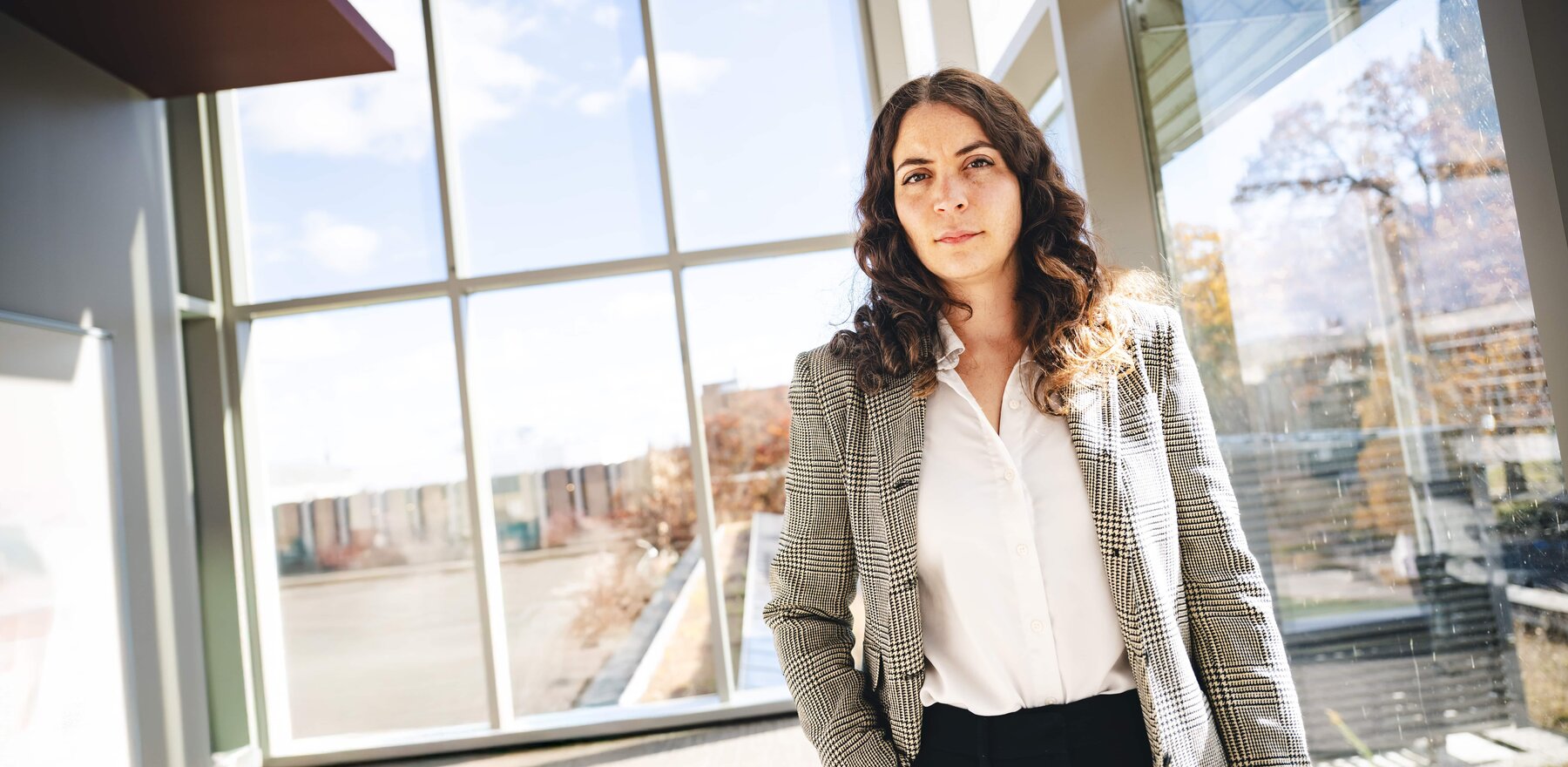 Sabrina Arias standing in a wide room with glass windows