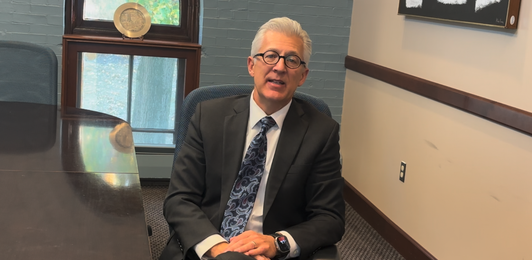 Scott Koerwer sitting in a chair in a conference room