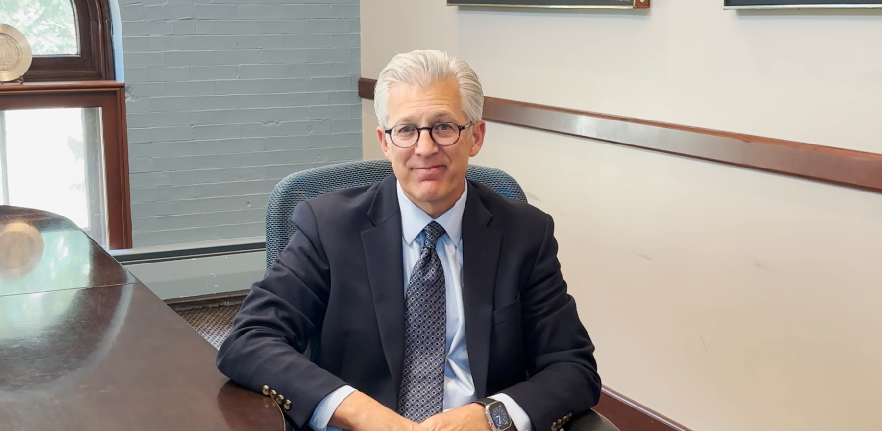 Scott Koerwer sitting in a chair in a conference room