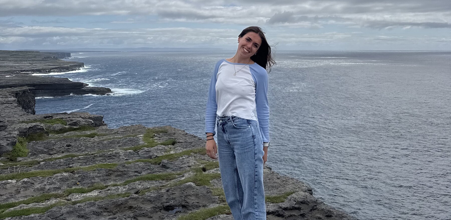 A young woman standing in front of a body of water in Ireland