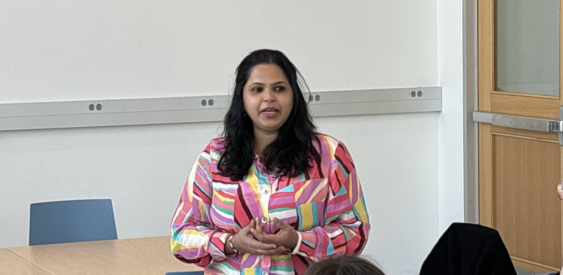 Vinita Desai talking to a group of people who are off-camera