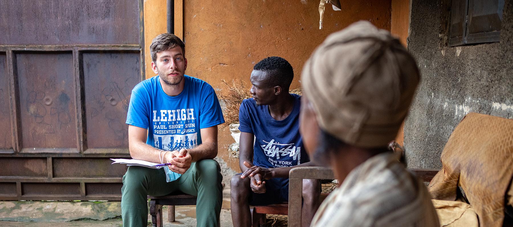 A student interviews a resident of Bududa, Uganda