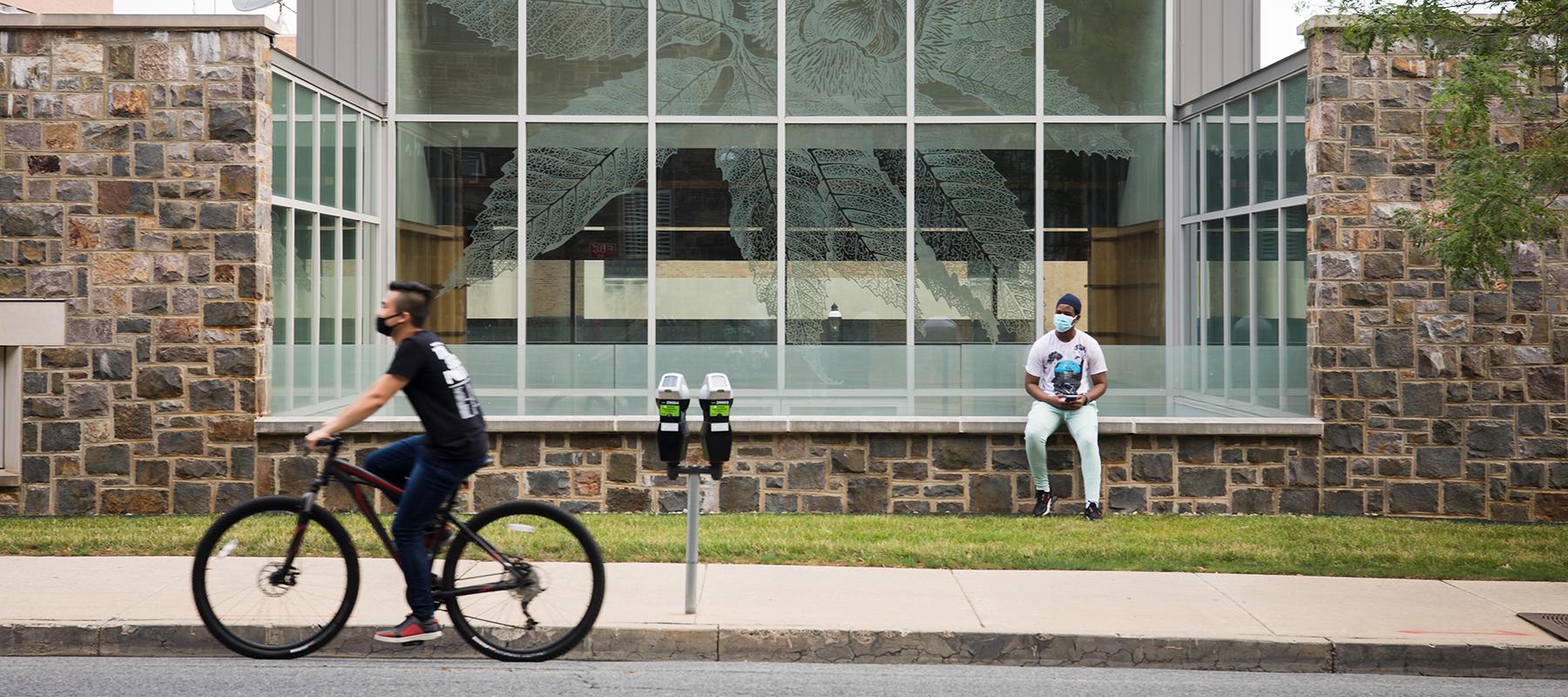 A student rides their bike in front of the STEPS Building at Lehigh University